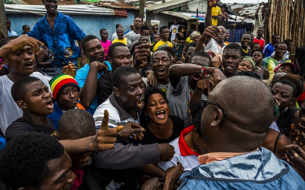   Residents of West Point, voice their grievances of lack of basic necessities to a member of the entourage of the Liberian President, Ellen Johnson Sirleaf, as they hand out money to residents, during the presidents visit to the quarantined neighbor