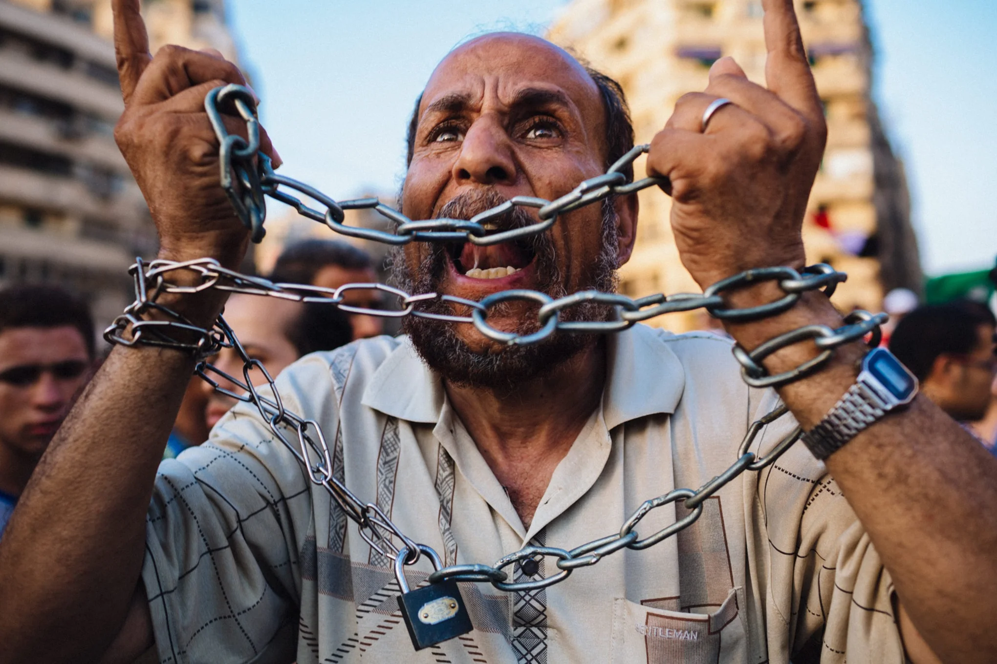A man bound in chains chants anti-Shafiq slogans as other Egyptian supporters of the Muslim Brotherhood celebrate a premature victory for their presidential candidate Mohamed Morsi in Cairo, Egypt. June 18, 2012 © Daniel Berehulak/Getty Images