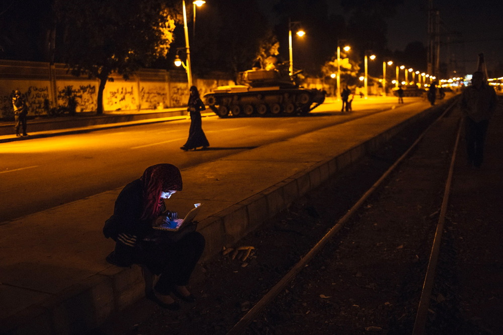   An Egyptian woman types on her laptop prior to the start of a demonstration opposing president Mohammed Morsi at the Presidential Palace in Cairo, Egypt. December 18, 2012 &nbsp;© Daniel Berehulak/Getty Images  