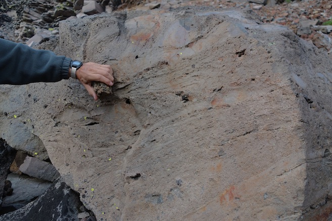A large block of swirly vesicular rock rests near the bottom of the hill.