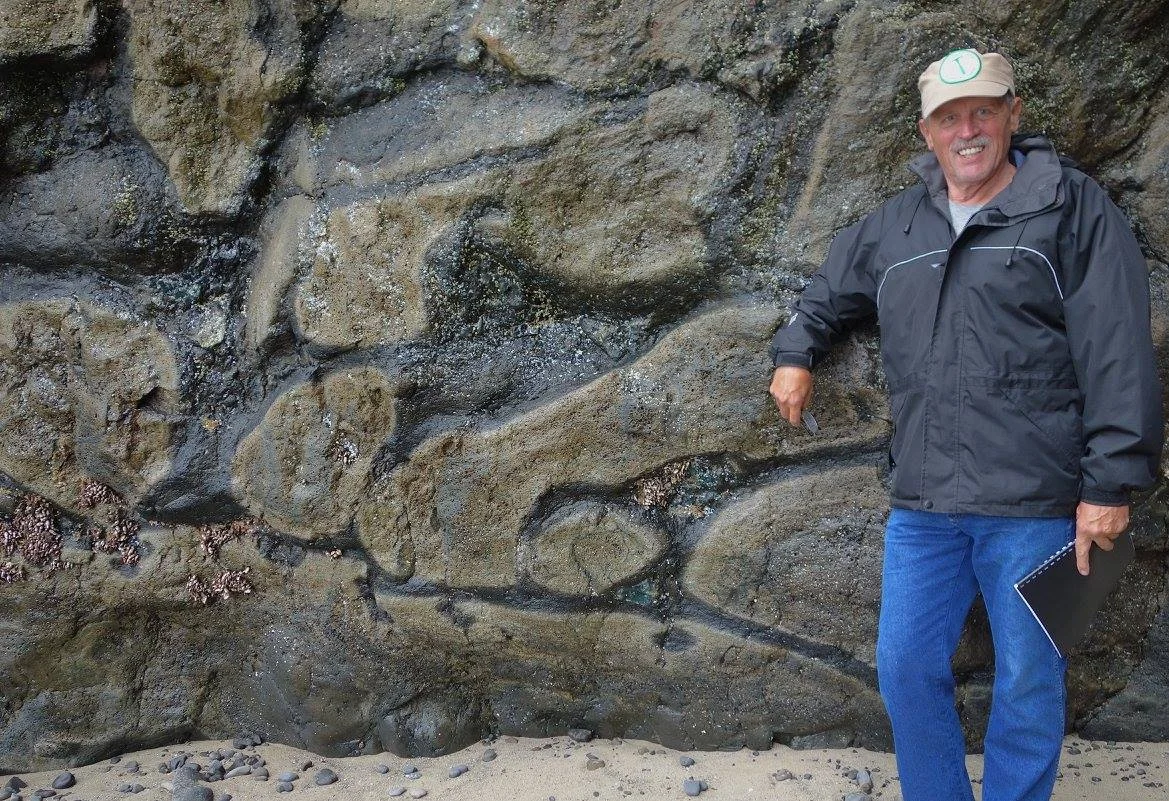Field trip leader, GSOC President Bo Nonn, posing next to some pillow basalts at Arcadia Beach.