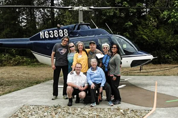 The GSOC field trip group poses with pilot Robert. Left to right are Steve Haar, Cecily Cedilote, Sheila Alfsen, pilot Robert, kneeling, Charles Montross, Anne Oneill, kneeling, Carol Hasenberg, Yumei Wang. Bo Nonn also participated in the trip.
