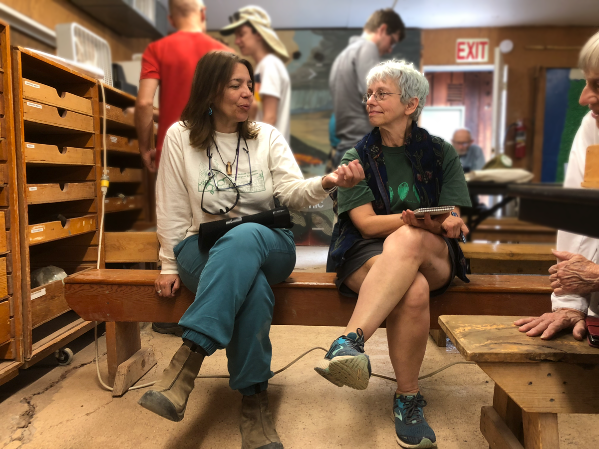 Board members Dawn Nilson (RCA) and Carol Hasenberg (GSOC) gather in Lon’s Lab for Orr’s Fossil ID session. Photo by Paul.