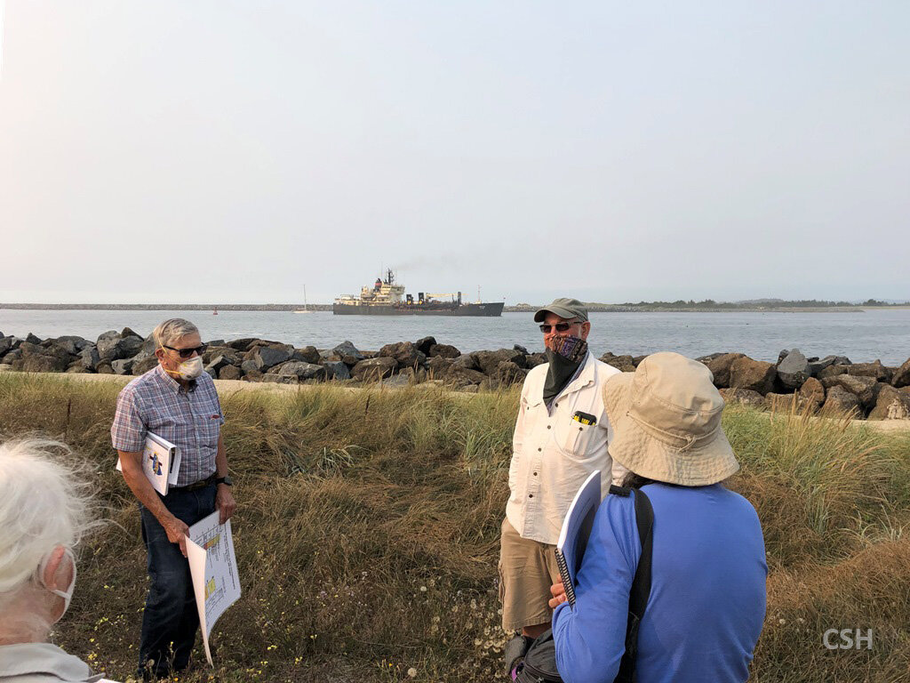  John and Dave tell us that the brownish black jetty rocks are Siletzia basalt whereas the bluer ones are blueschist. In the background the dredge is working in the Coos Bay entrance bar. 