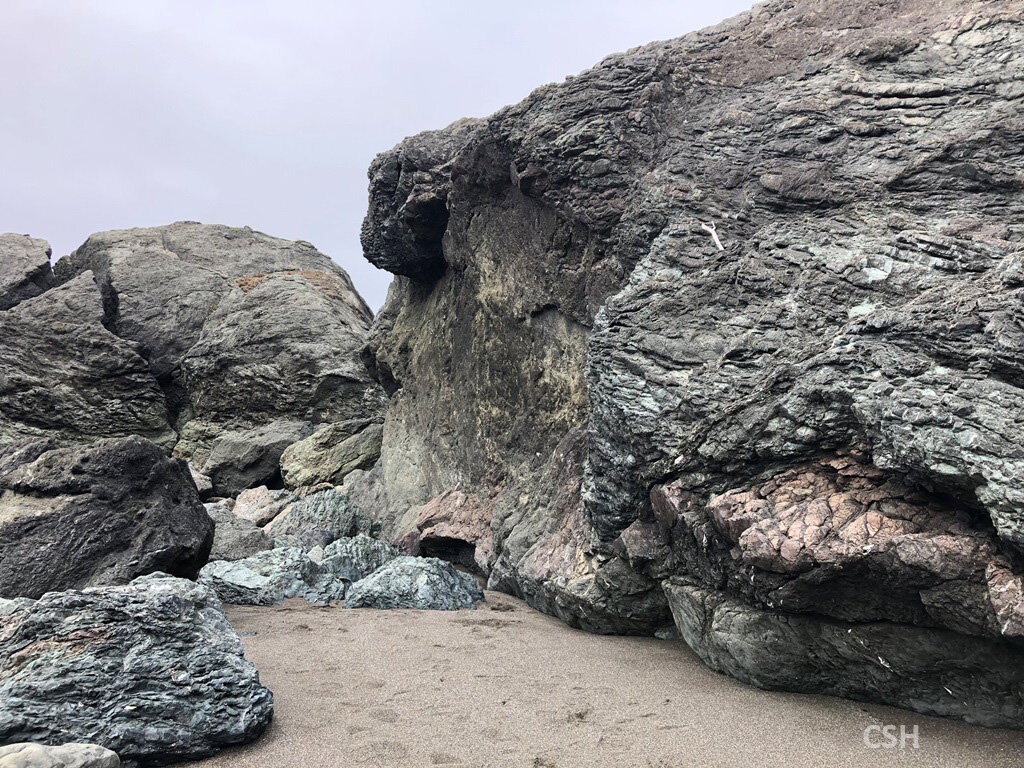  Because they have been through the subduction zone “meat grinder”, different rock types are found on the same boulders. Here we have basalt, radiolarian chert, and mudstone on the boulder to the right.  