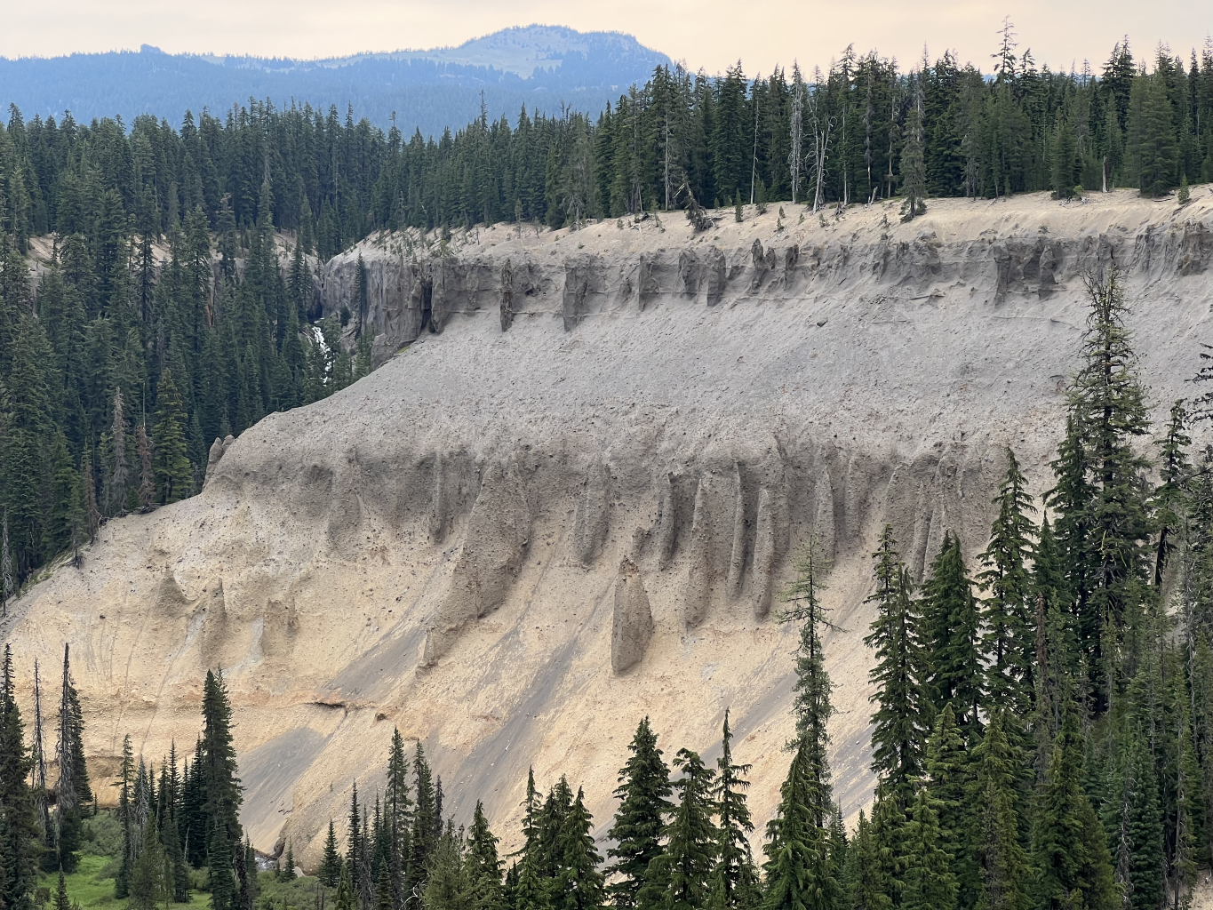  Stop 1 – This incredible deposit of ash fall and tuff at Annie Creek Canyon represents a total inversion of the magma chamber in the ring vent phase of the climactic eruption. Notice that the color of the material goes from buffy at the bottom to gr