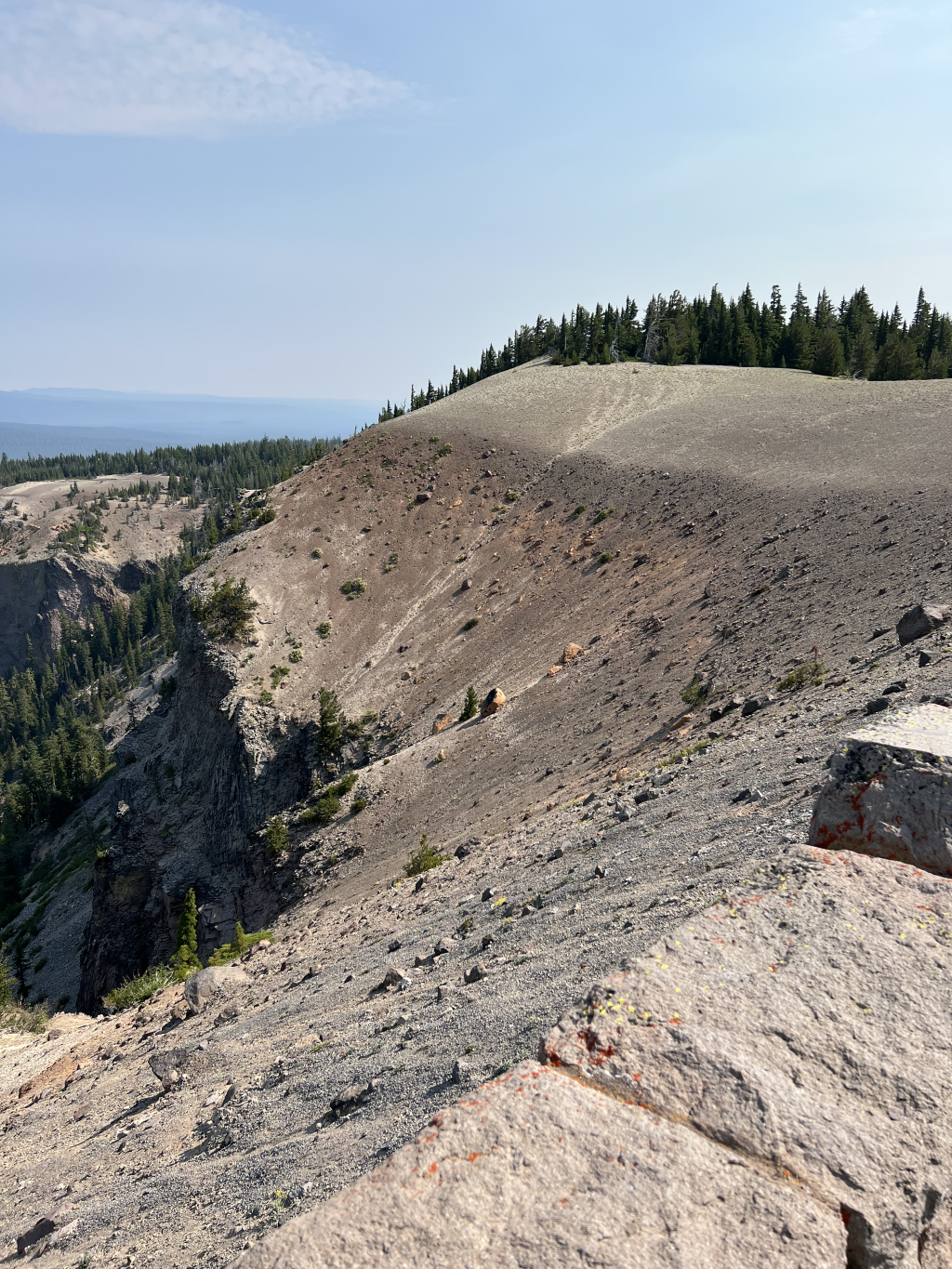  This escarpment clearly shows all the phases of the climactic eruption. The central vent erupted first, so the buff layer at the bottom came from this vent. The welded orange tuff above that is the Wineglass Welded Tuff from the pyroclastic flows at
