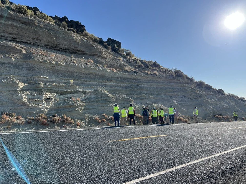  The group examines the roadcut at the base of the hill. 