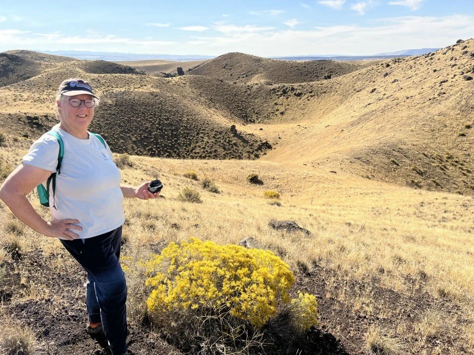  Carole posed for this shot with the bomb, rabbit brush, and the craters beyond. 