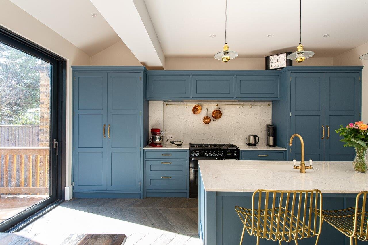 Blue kitchen with integrated fridge and large double door larder.