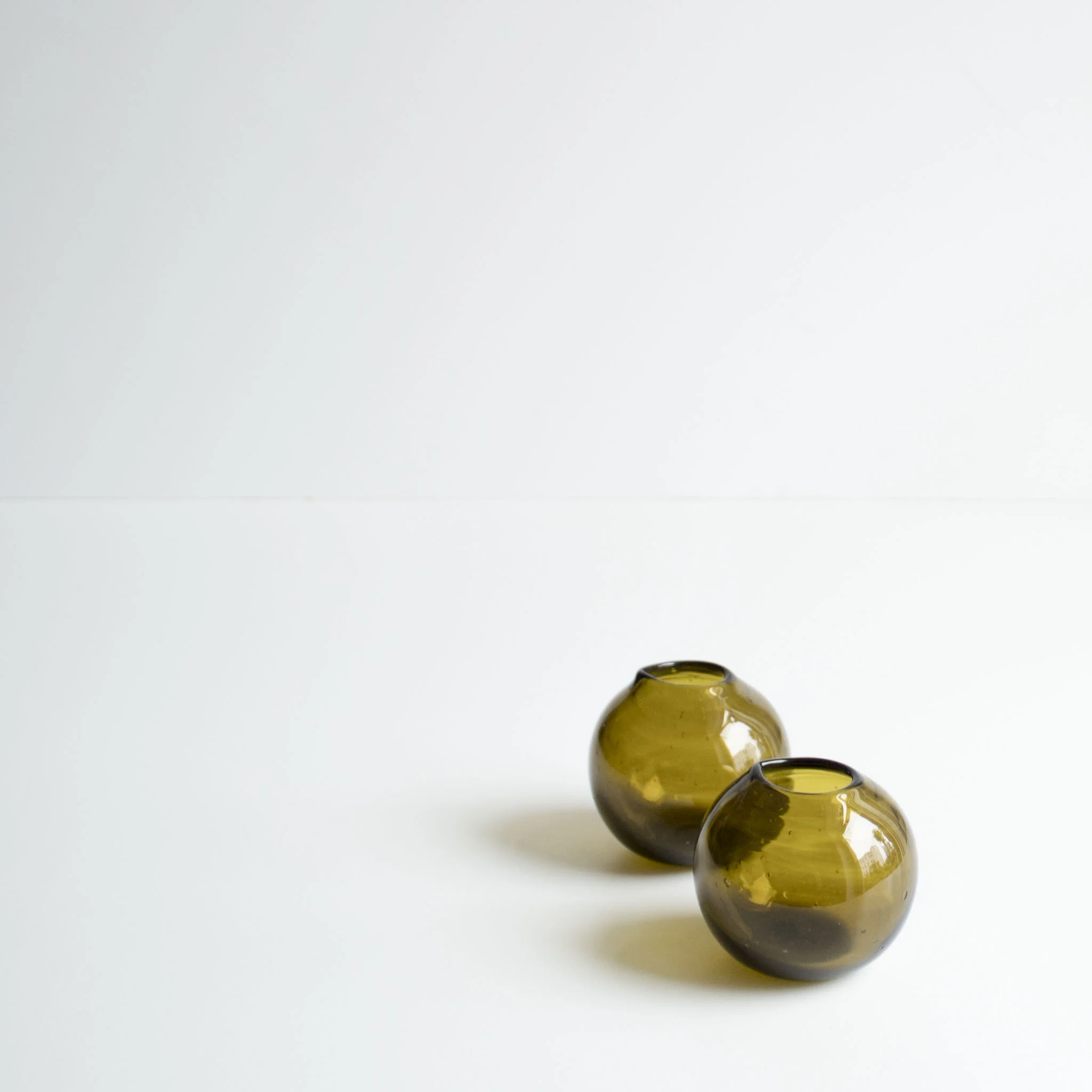 Small glass jugs made from 100 % recycled glass in green mix.
