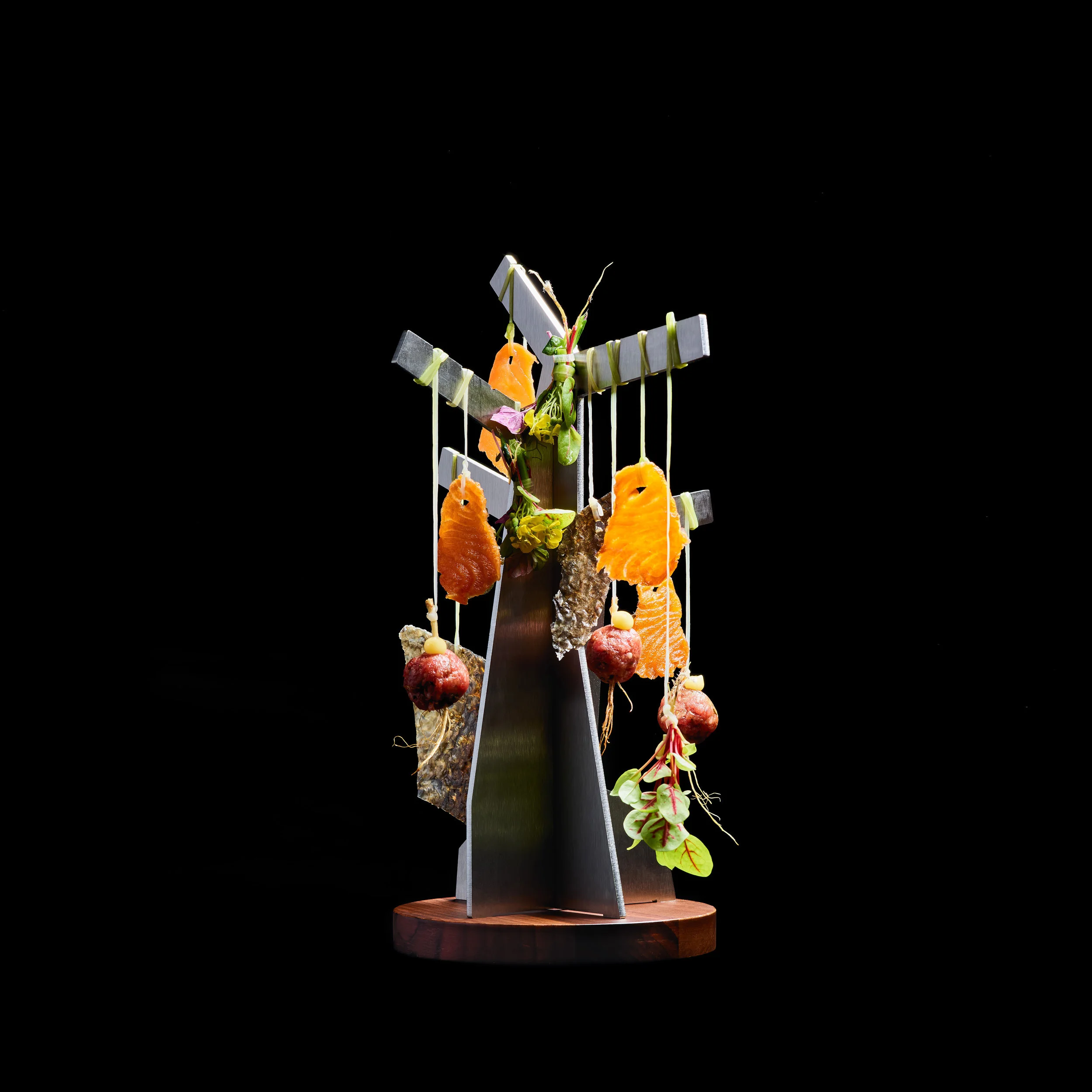 The Sketches collection represents a variety of materials with porcelain as the core. The appetizer tree is made from stainless steel and has a wooden base.