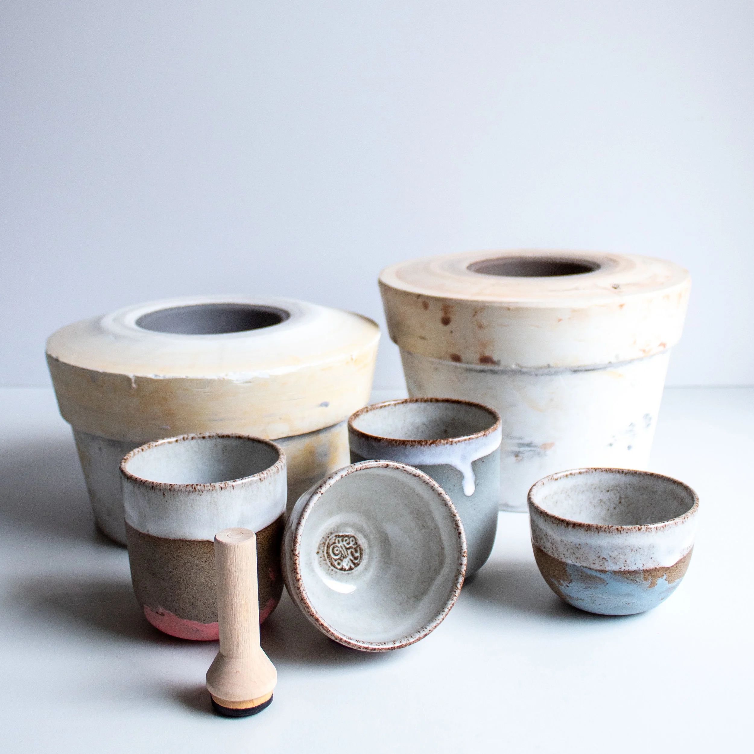 The plaster moulds in the background are used for making the cups.