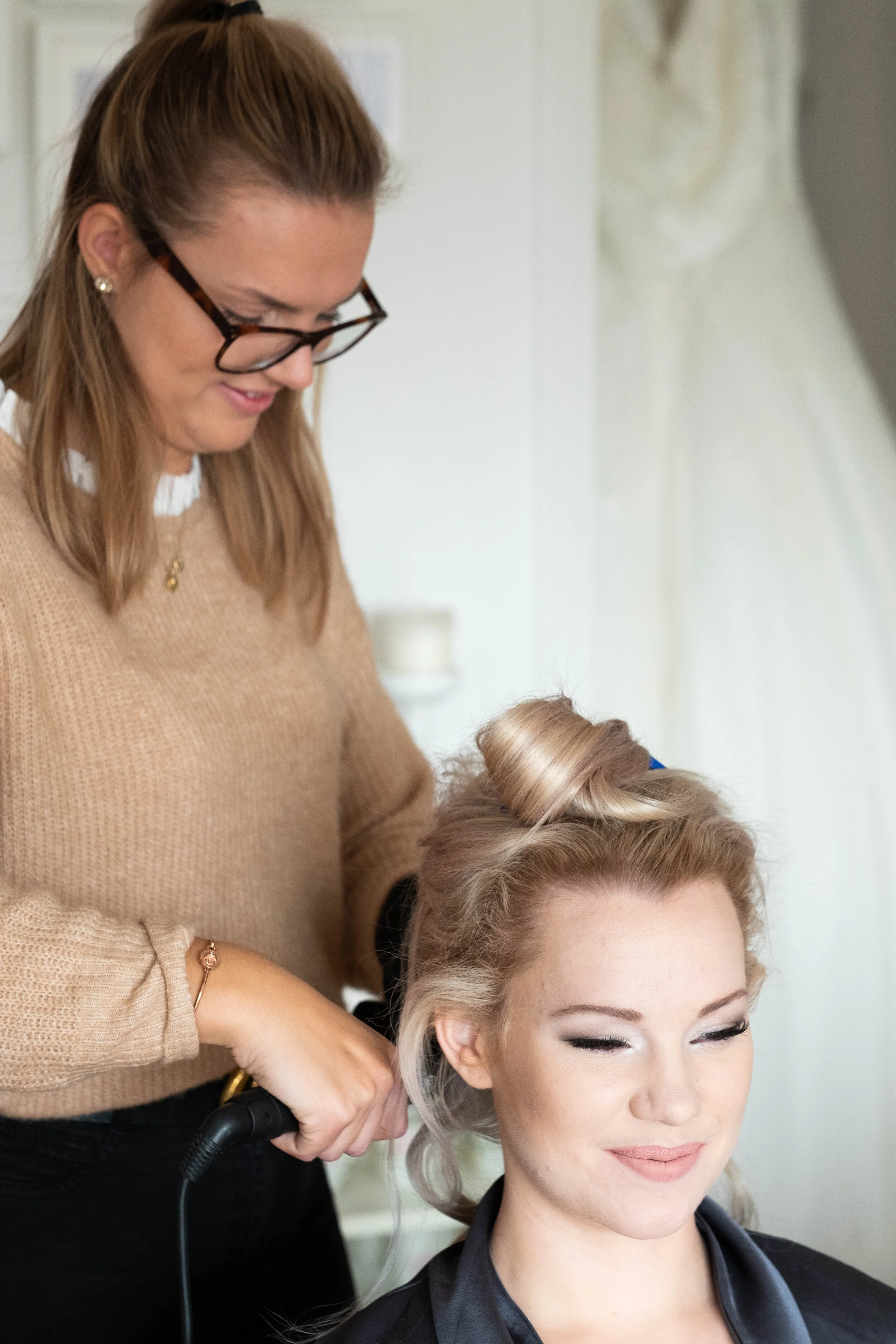 Här pågår hårstyling av brud, frisören Rebecca Johansson fixar lockar i eget hår och löshår till ett högst värdigt hårsvall för dagen