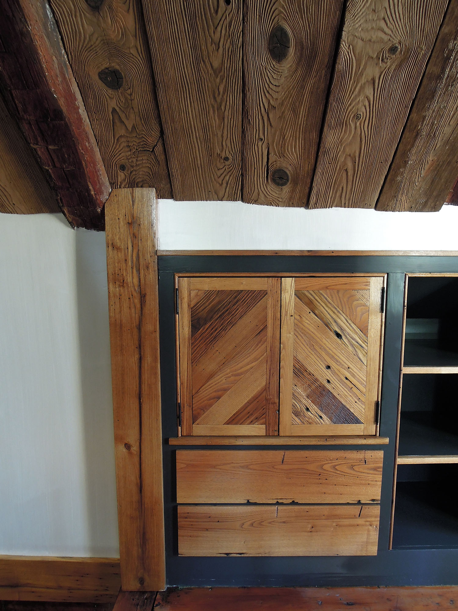 We modified the existing built- in cabinets by adding the drawer faces to the bottom section, and building the custom chevron pattern doors for the top. All were made with reclaimed chestnut. 