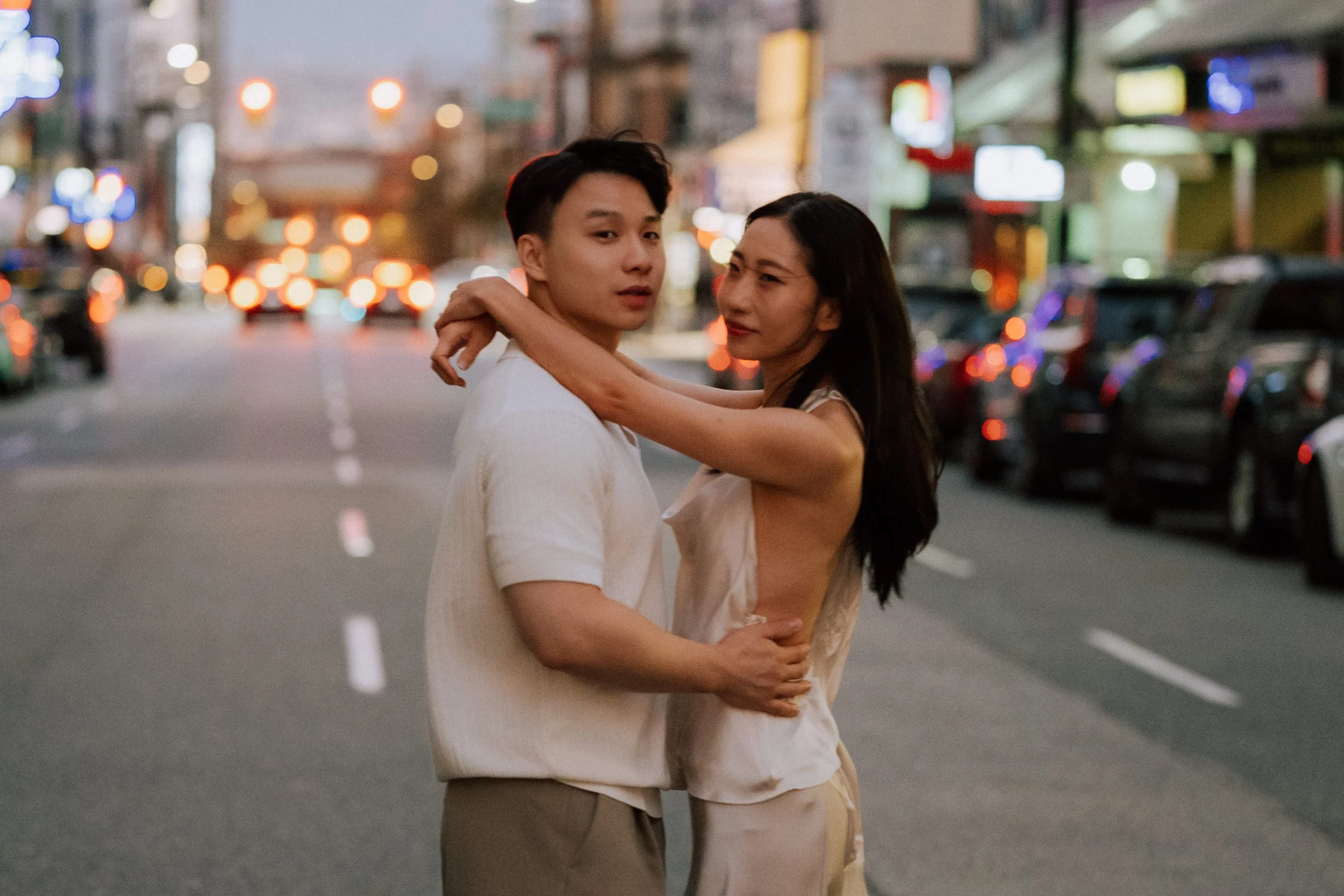 Couple embracing during an engagement session in Downtown Vancouver at dusk.