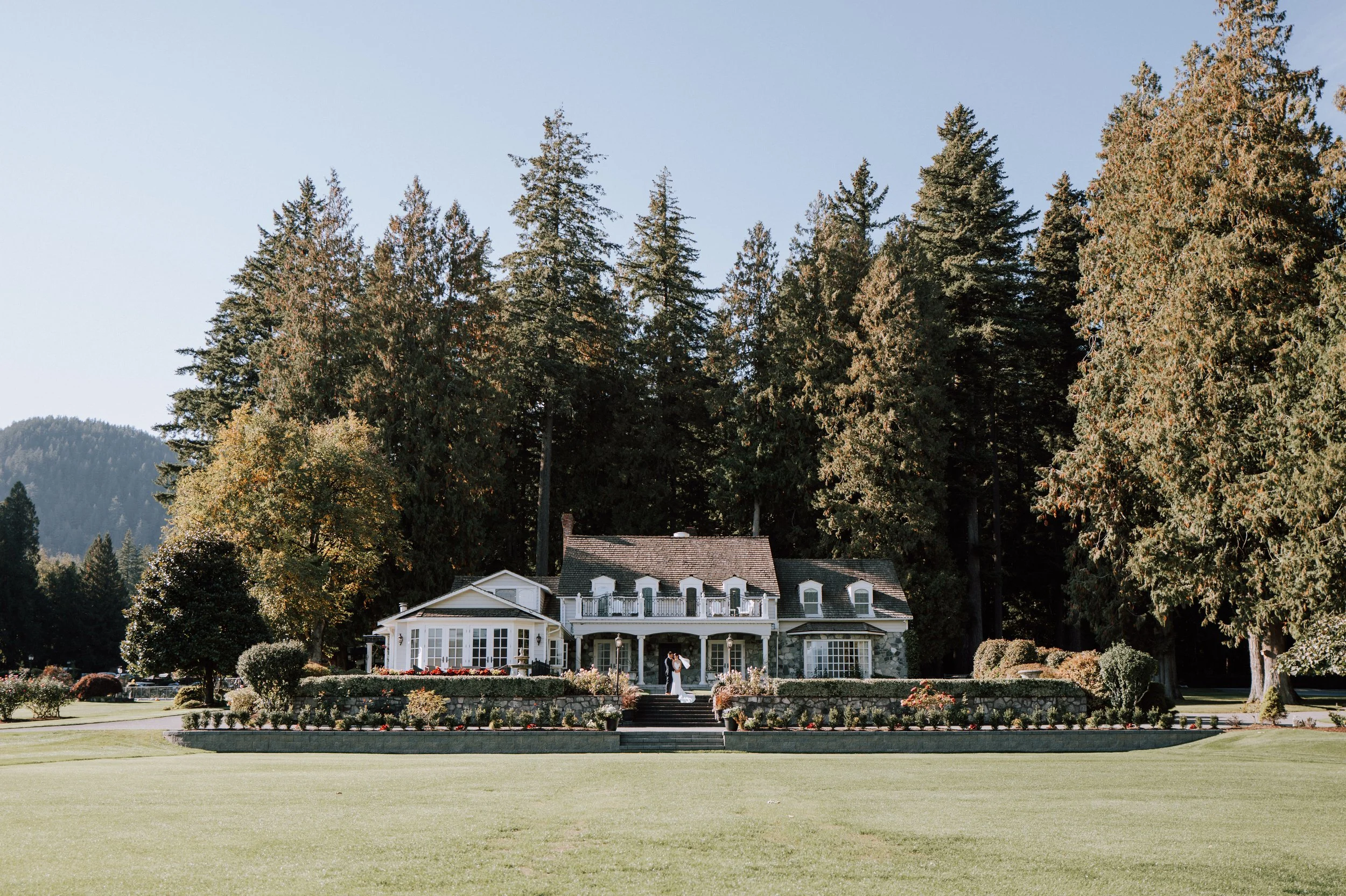 Bride and groom embracing in front of Sandpiper Resort in Harrison Mills, British Columbia.