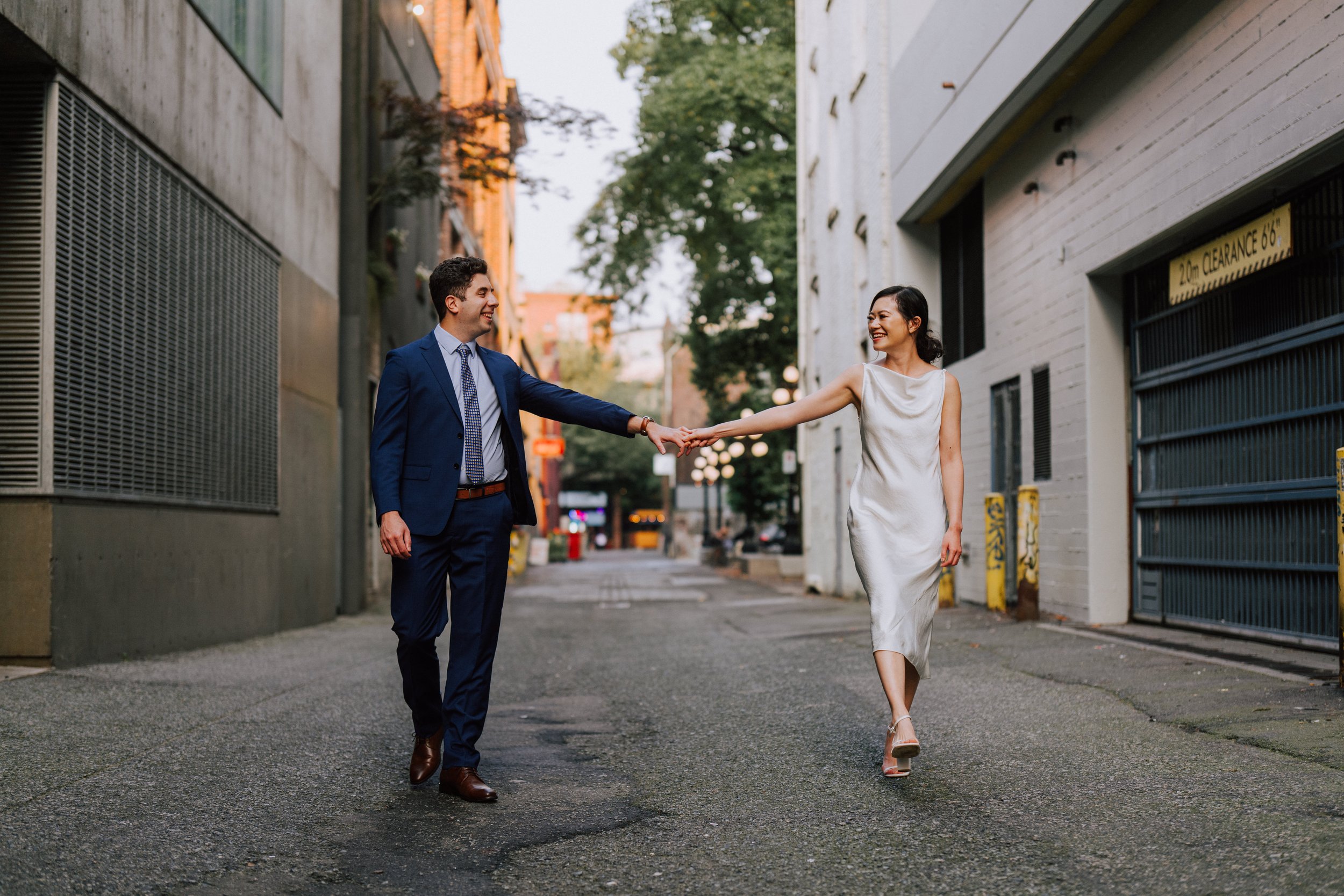 Bride and groom walking hand in hand during wedding portraits in Gastown, Vancouver.