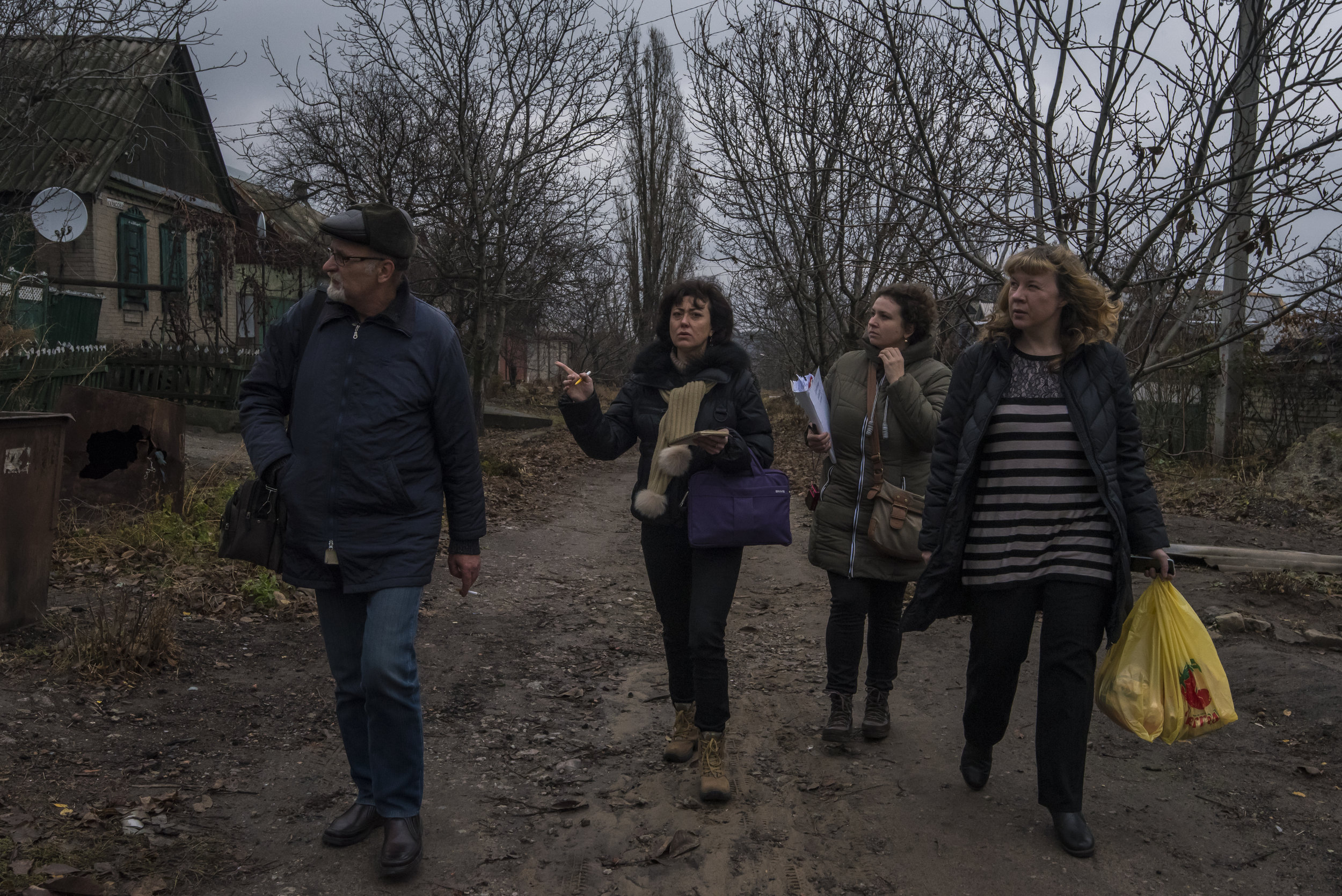  Kyiv-based voulnteers Ksenia Ponomarjova, Irina Shopina, and Veronika Korol look for the home of an elderly woman with local doctor Dr. Sergei Yakovlevich in Avdiivka, Ukraine. 