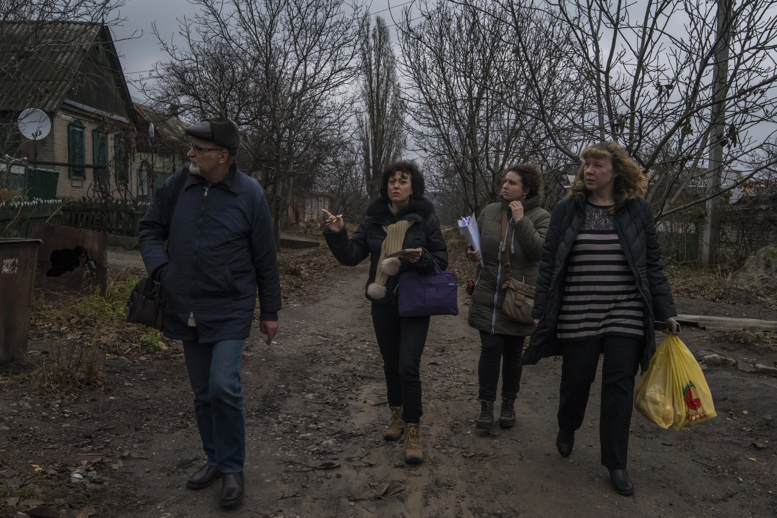 Kyiv-based voulnteers Ksenia Ponomarjova, Irina Shopina, and Veronika Korol look for the home of an elderly woman with local doctor Dr. Sergei Yakovlevich in Avdiivka, Ukraine.