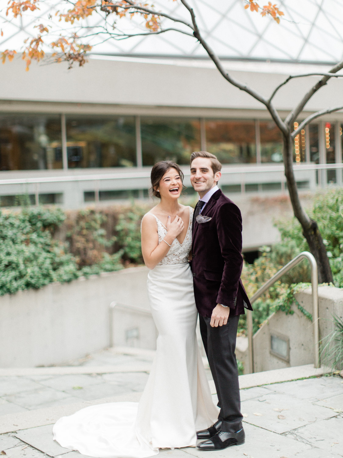- candid photograph of bride and groom laughing while posing for wedding photographs in Downtown Toronto. Captured by Toronto wedding photographer Corynn Fowler Photography.