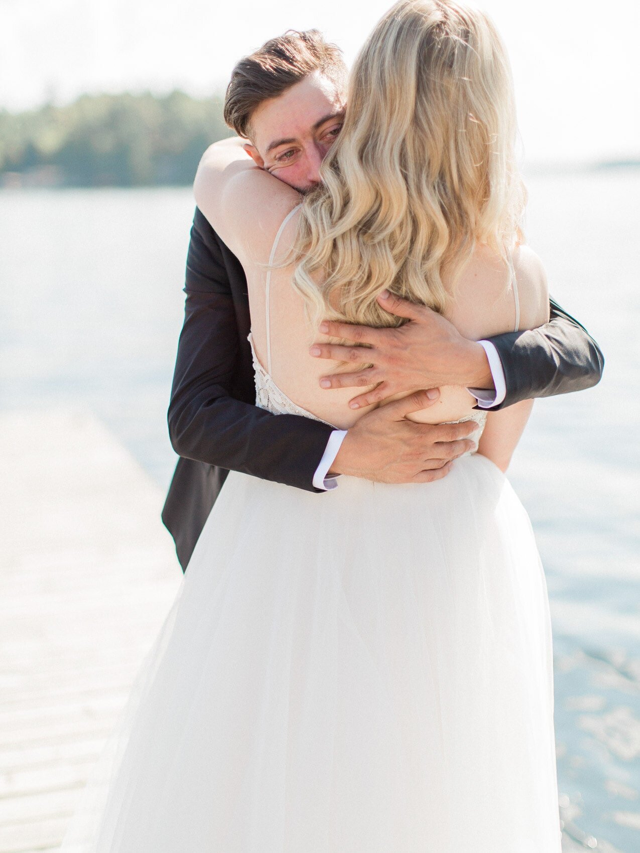 candid and emotional first look between bride and groom on the dock at windermere house muskoka