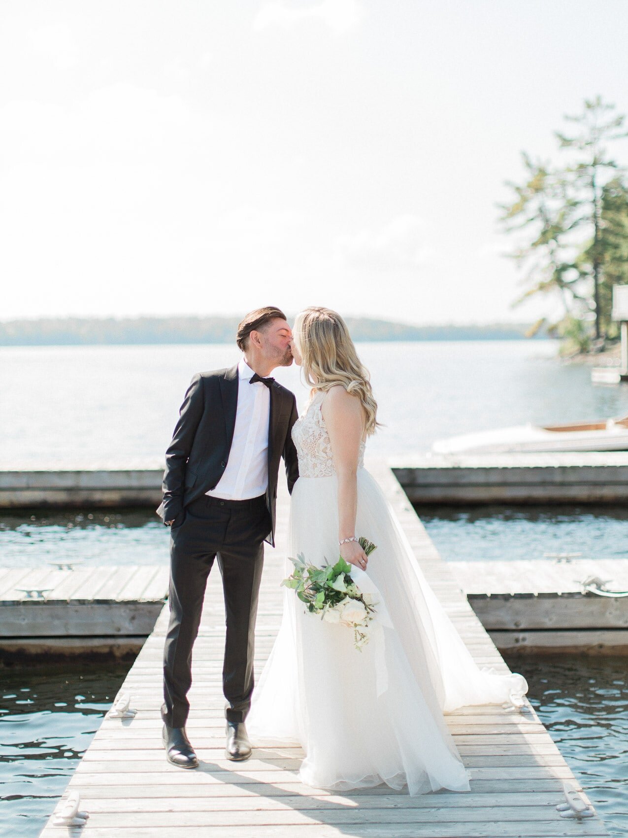 bride and groom posing naturally for a candid happy photo on their wedding day at windermere house muskoka