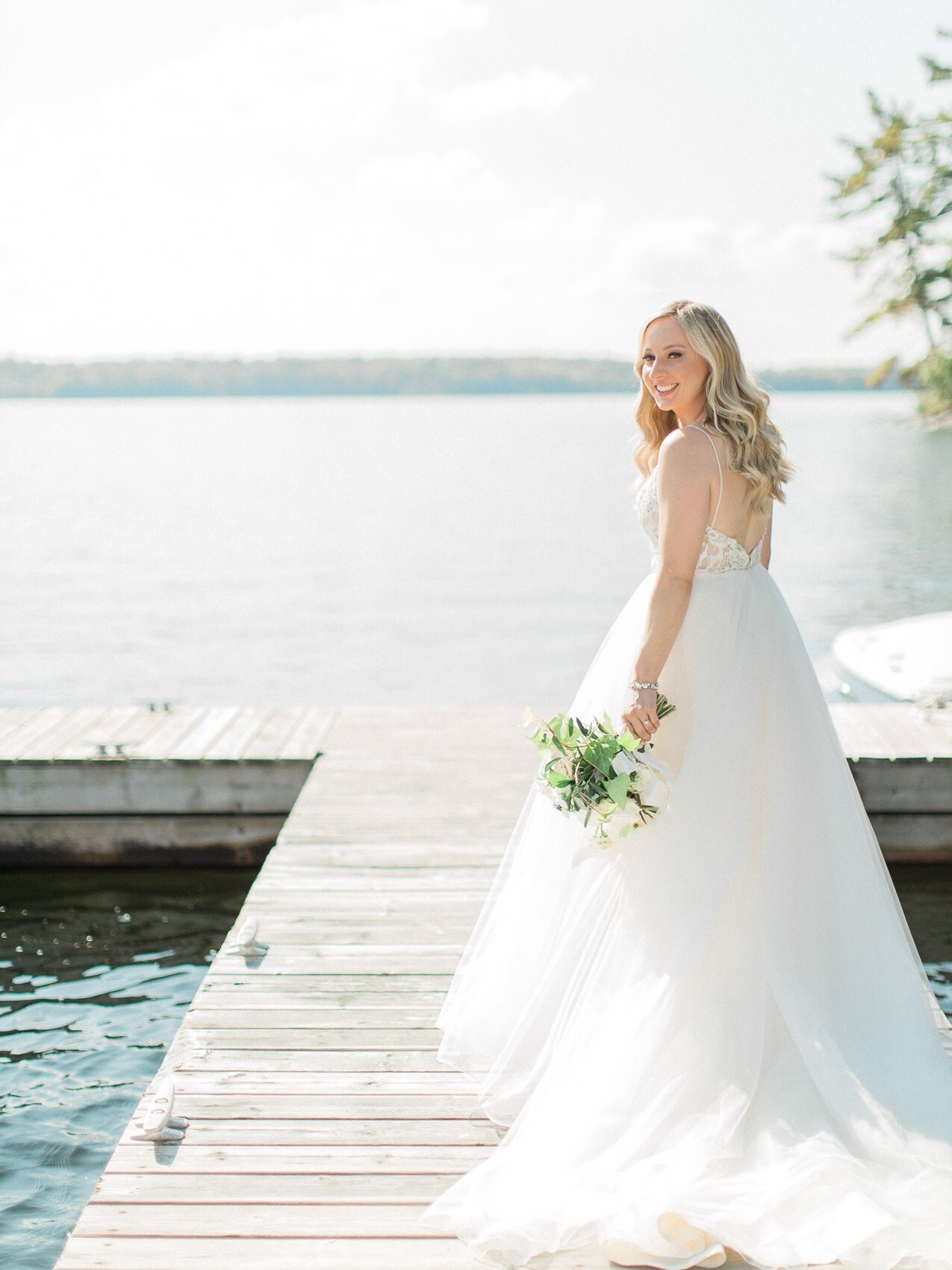 bride posing naturally for a candid happy photo on her wedding day at windermere house muskoka