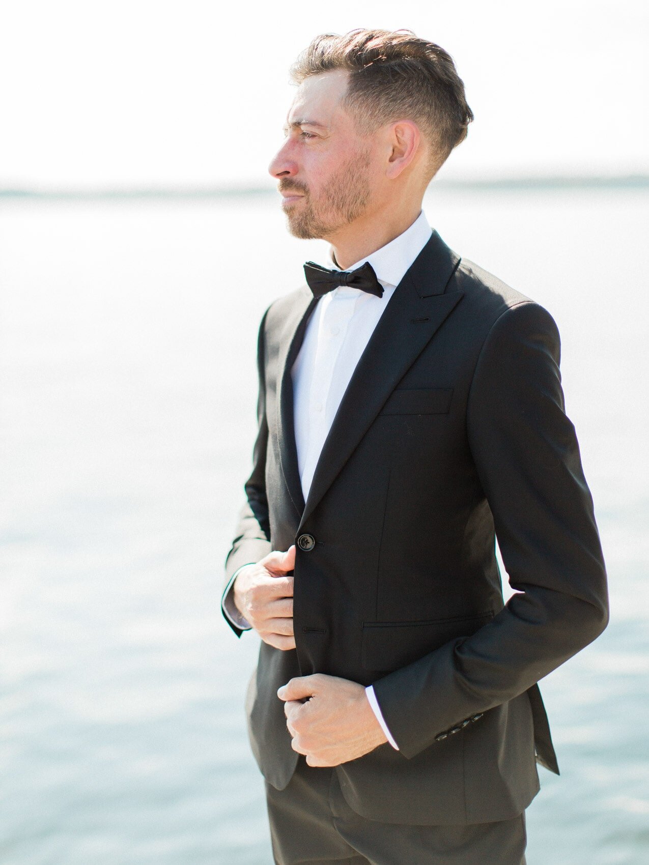 groom posing naturally for a candid happy photo on his wedding day at windermere house muskoka