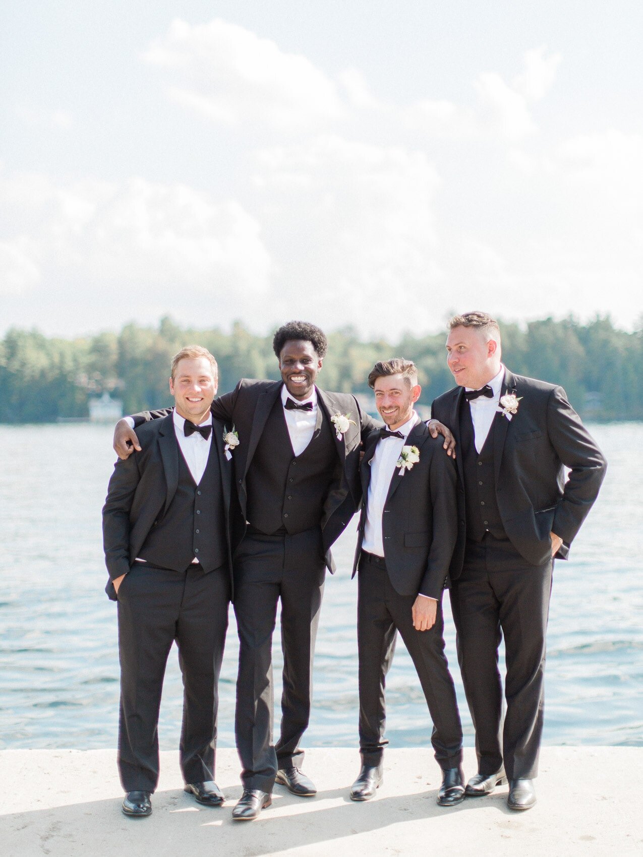 groomsmen posing naturally for a candid happy photo at a wedding at windermere house muskoka