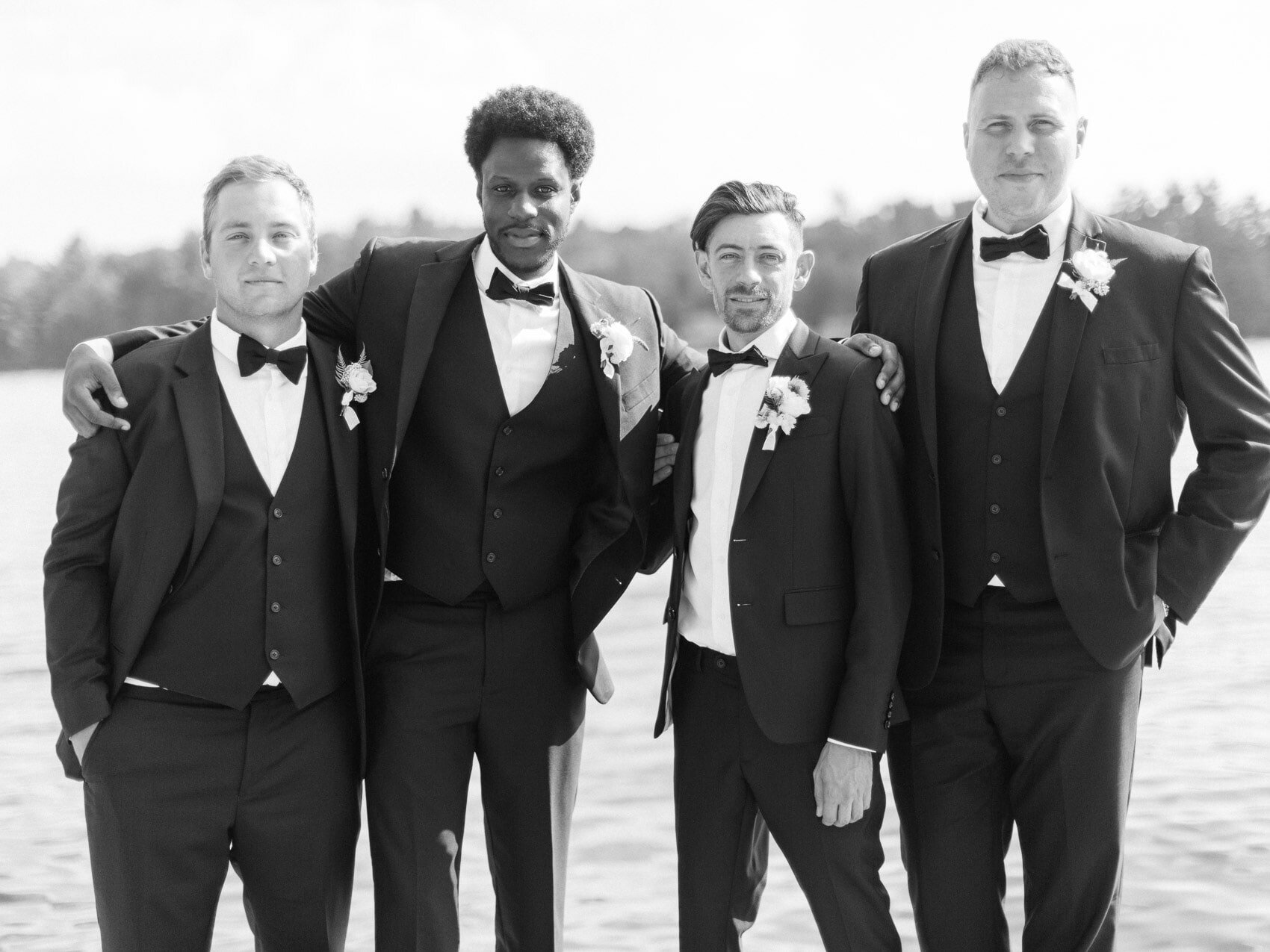 groomsmen posing naturally for a candid happy photo at a wedding at windermere house muskoka