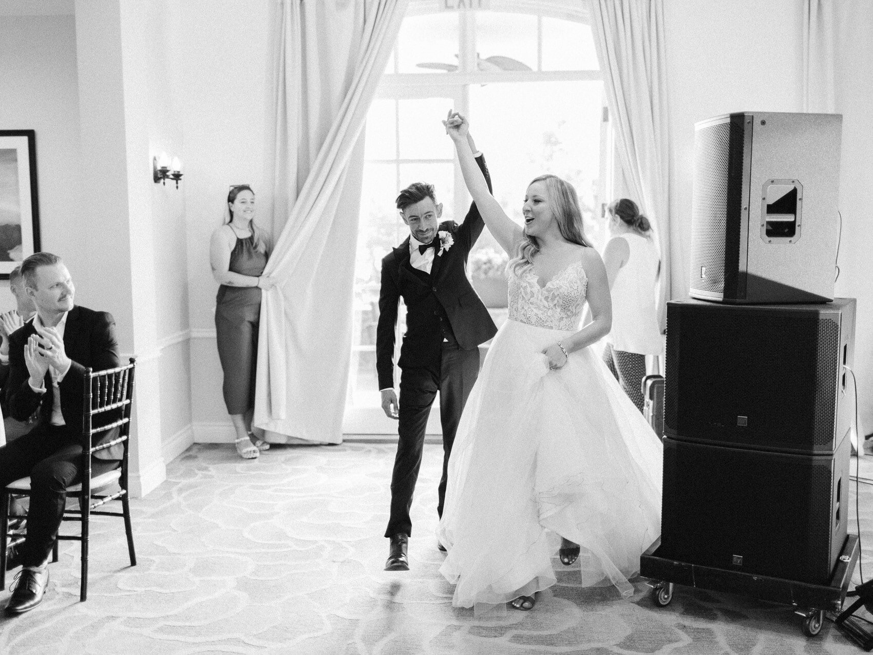 bride and groom's candid grand entrance to their wedding reception at windermere house muskoka