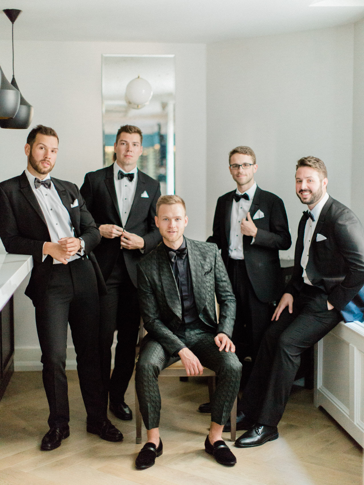 stylish and chic groom and groomsmen posing naturally for wedding party photos at the national club in Toronto