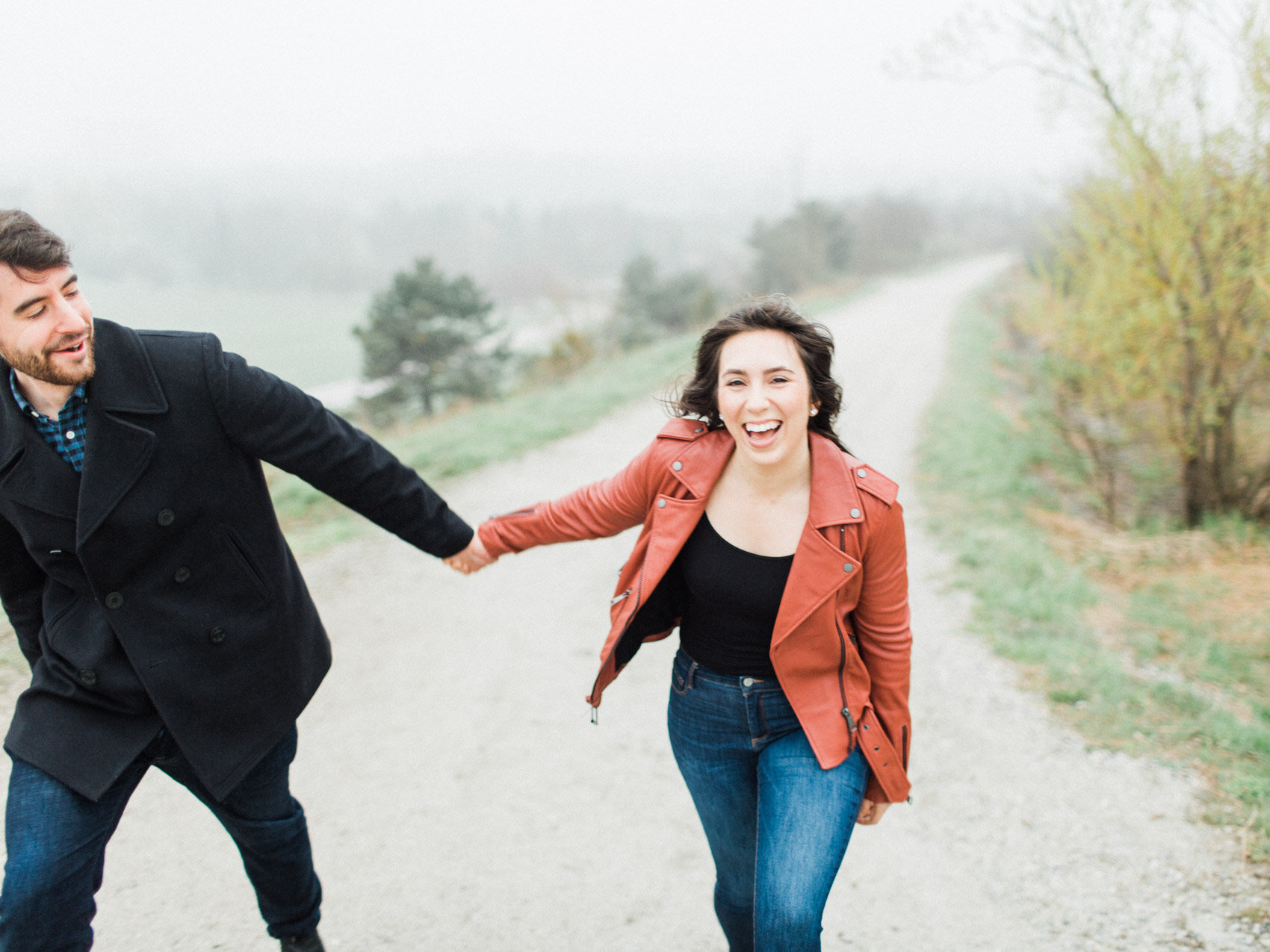 happy couple in the fog for an outdoor spring engagement session with cherry blossoms