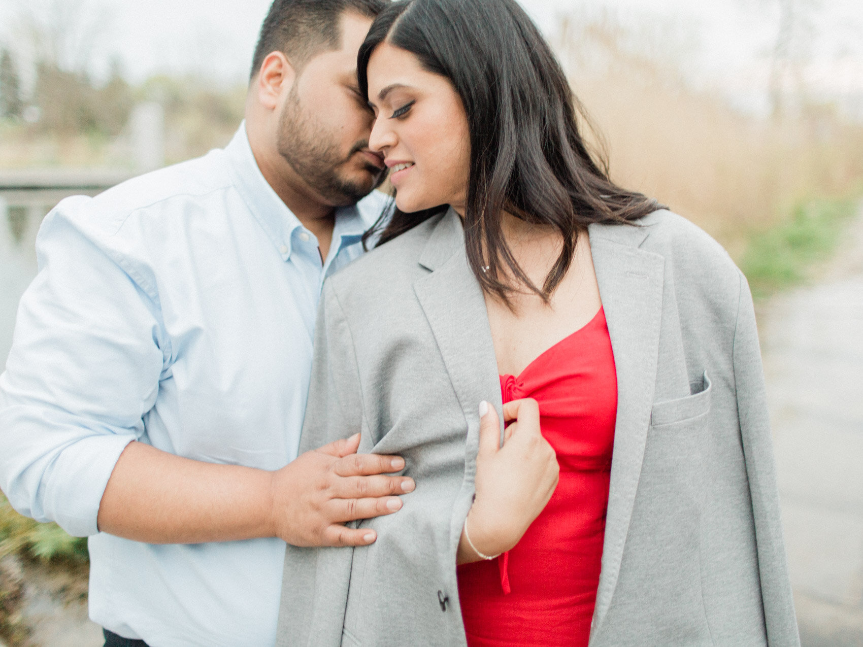 indian couple photographed during a candid moment at their outdoor engagement photography session at the scarborough bluffs in toronto