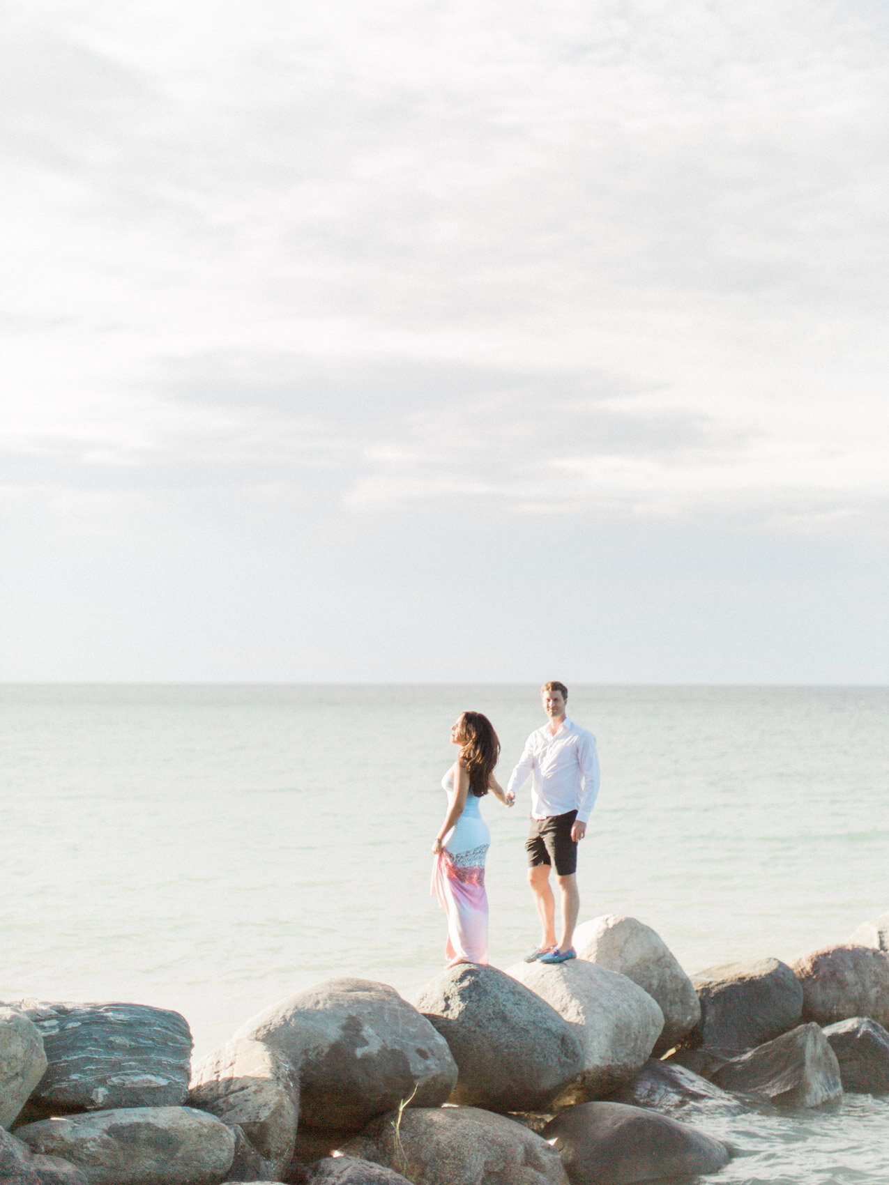 adventure engagement photography session couple holding hands by the lake in collingwood