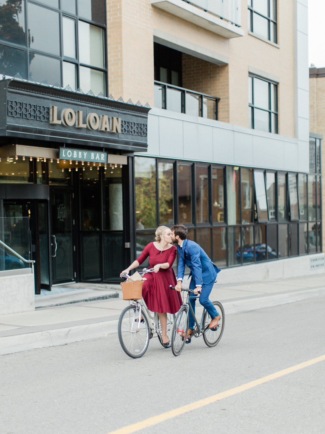 engaged couple riding bikes in downtown toronto for their fall engagement photography session