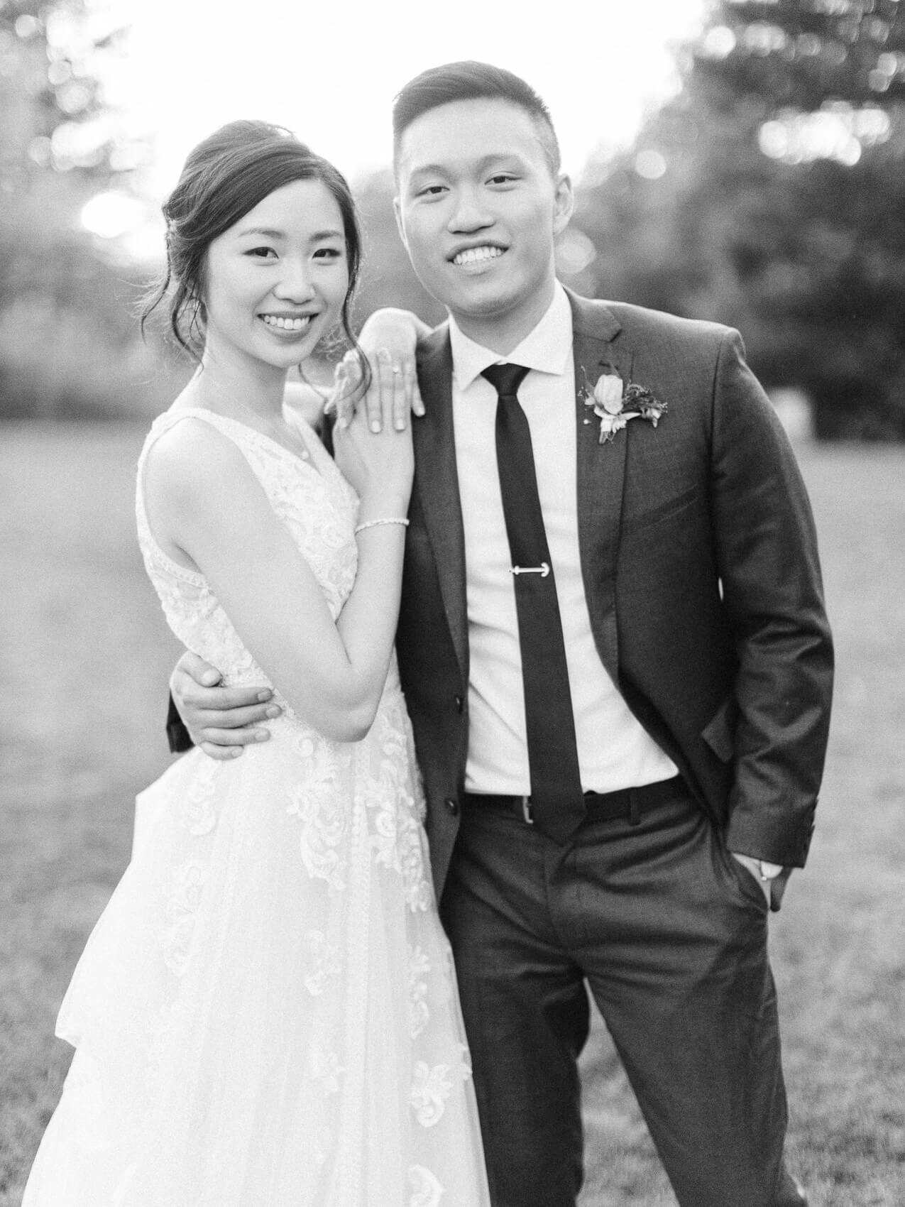 bride and groom posing naturally for their wedding photographs at the manor at sunset