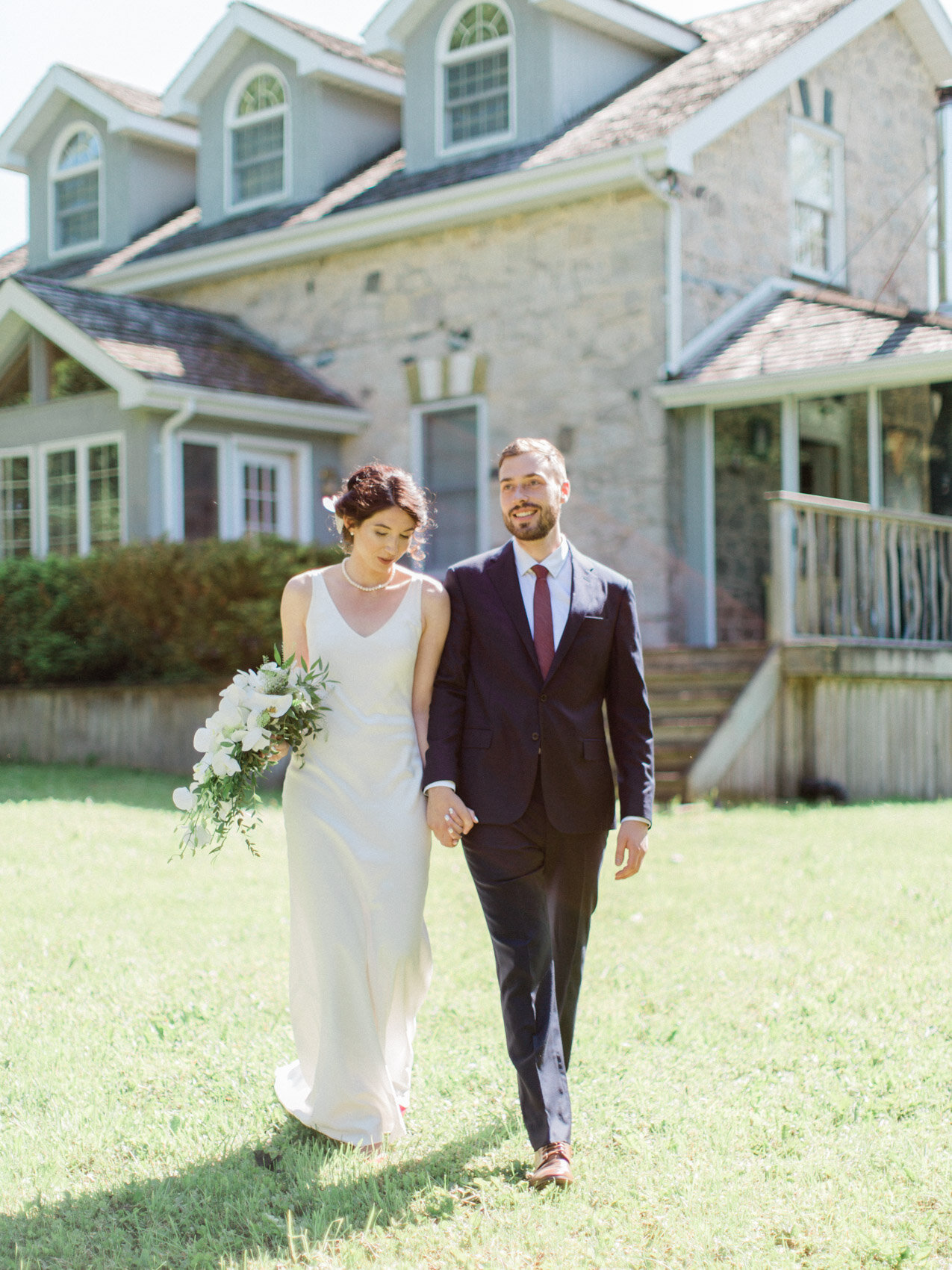 bride and groom pose naturally by walking at their outdoor summer wedding at silver springs retreat