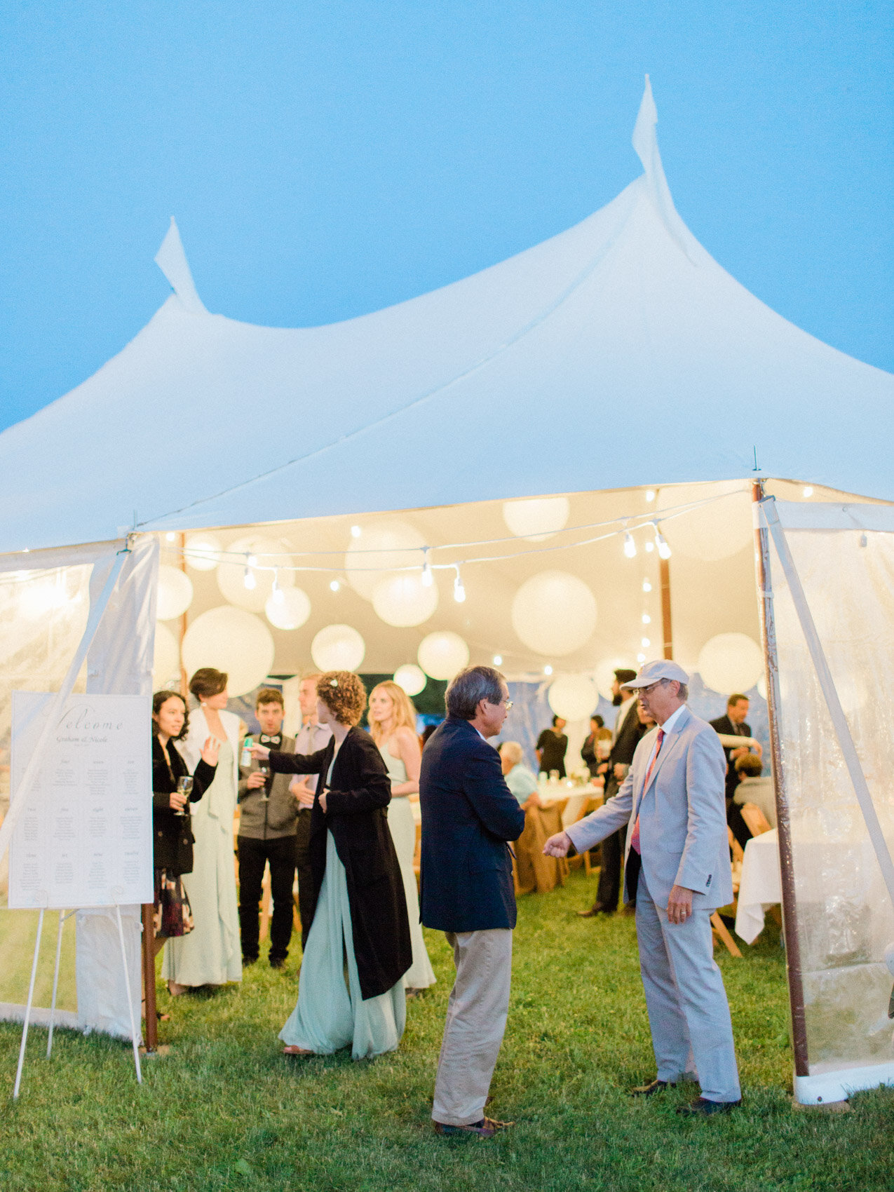 a beautiful circus top tent with floating lanterns at an outdoor summer wedding