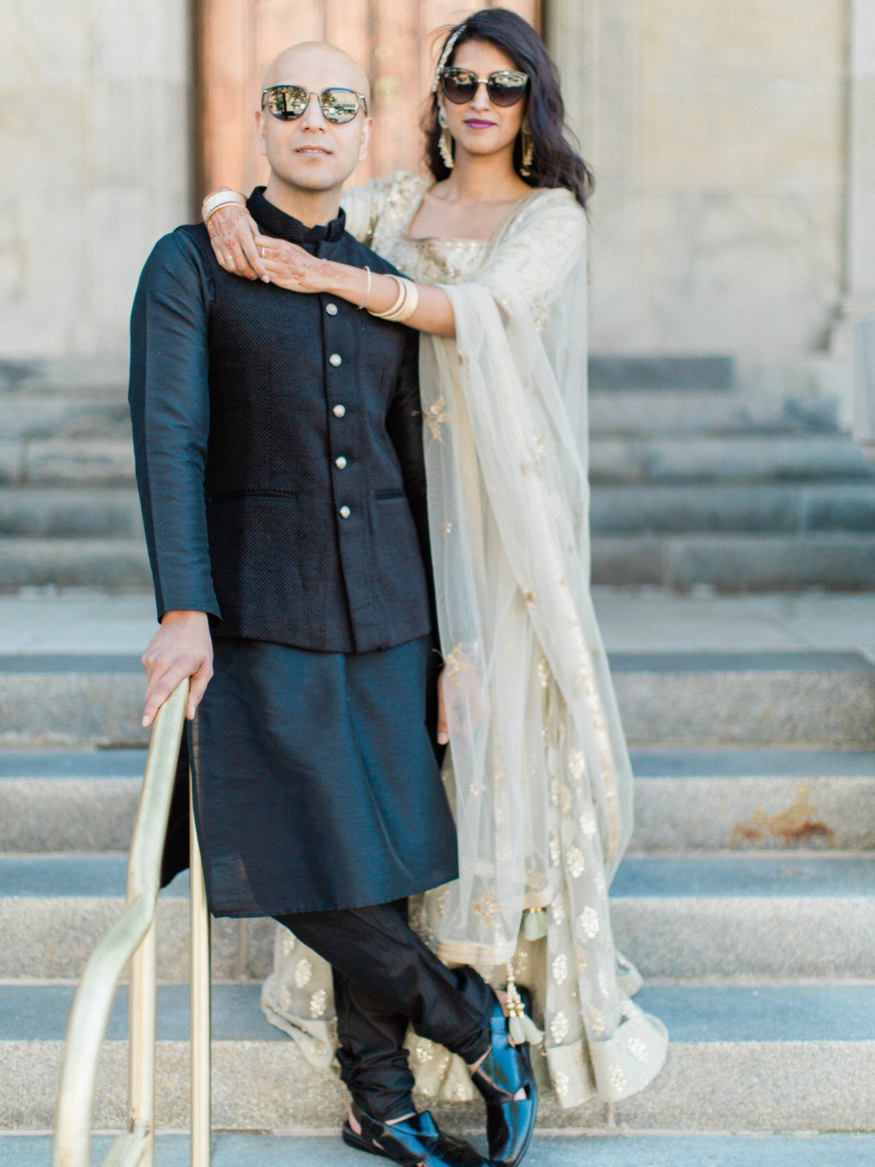 A chic indian couple posing naturally on the court house steps for their engagement photographs