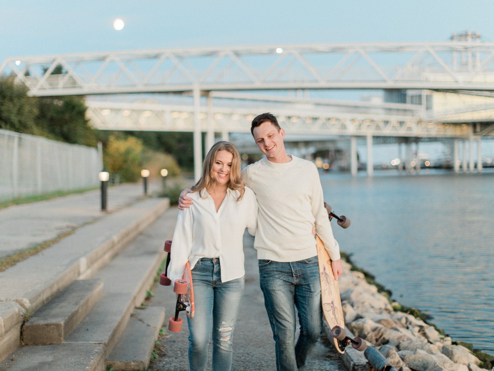 A relaxed couple with their longboards at their engagement session in Toronto