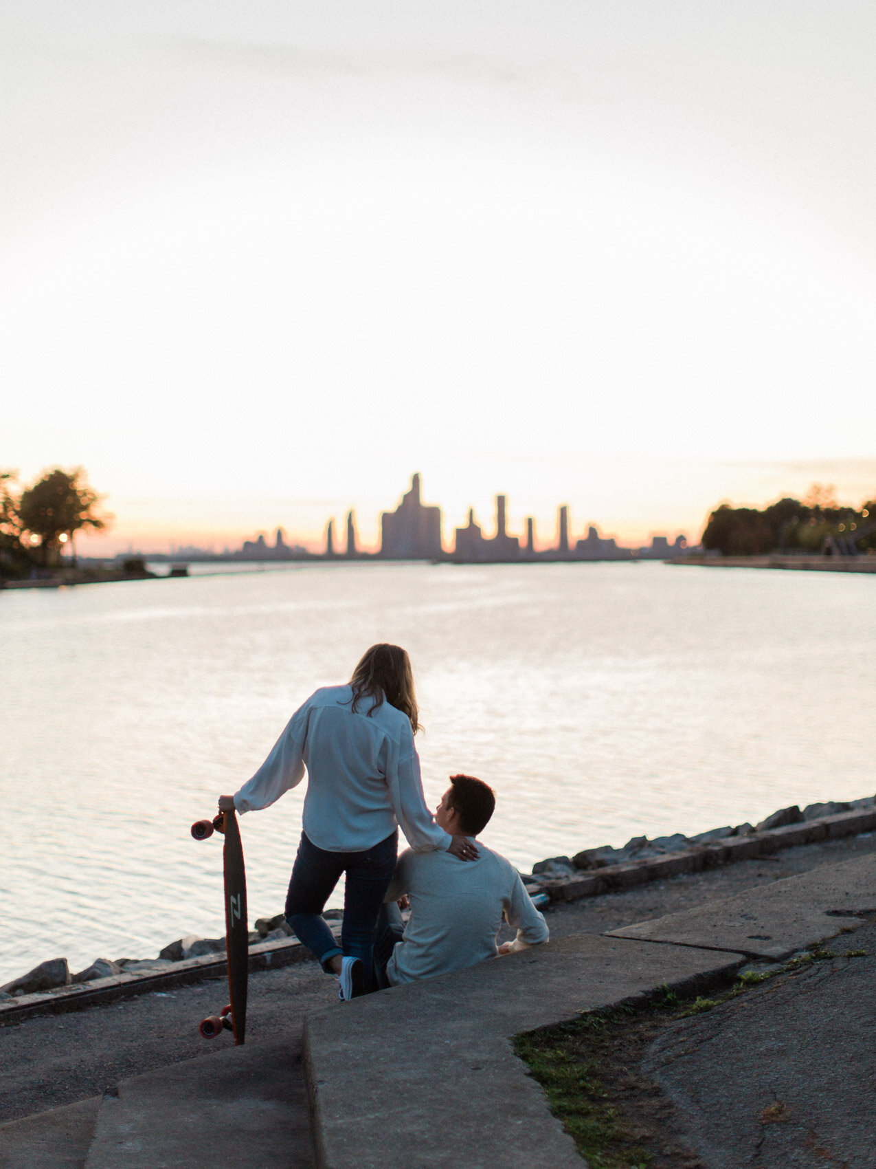 A relaxed couple with their longboards at their engagement session in Toronto