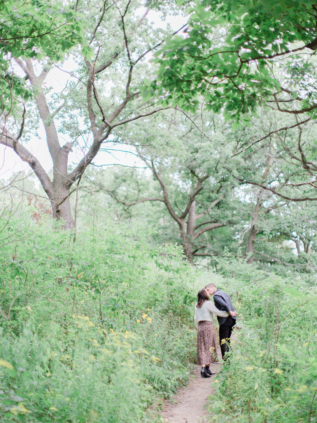 cute candid couple laughing at their engagement photographs in high park, posed naturally