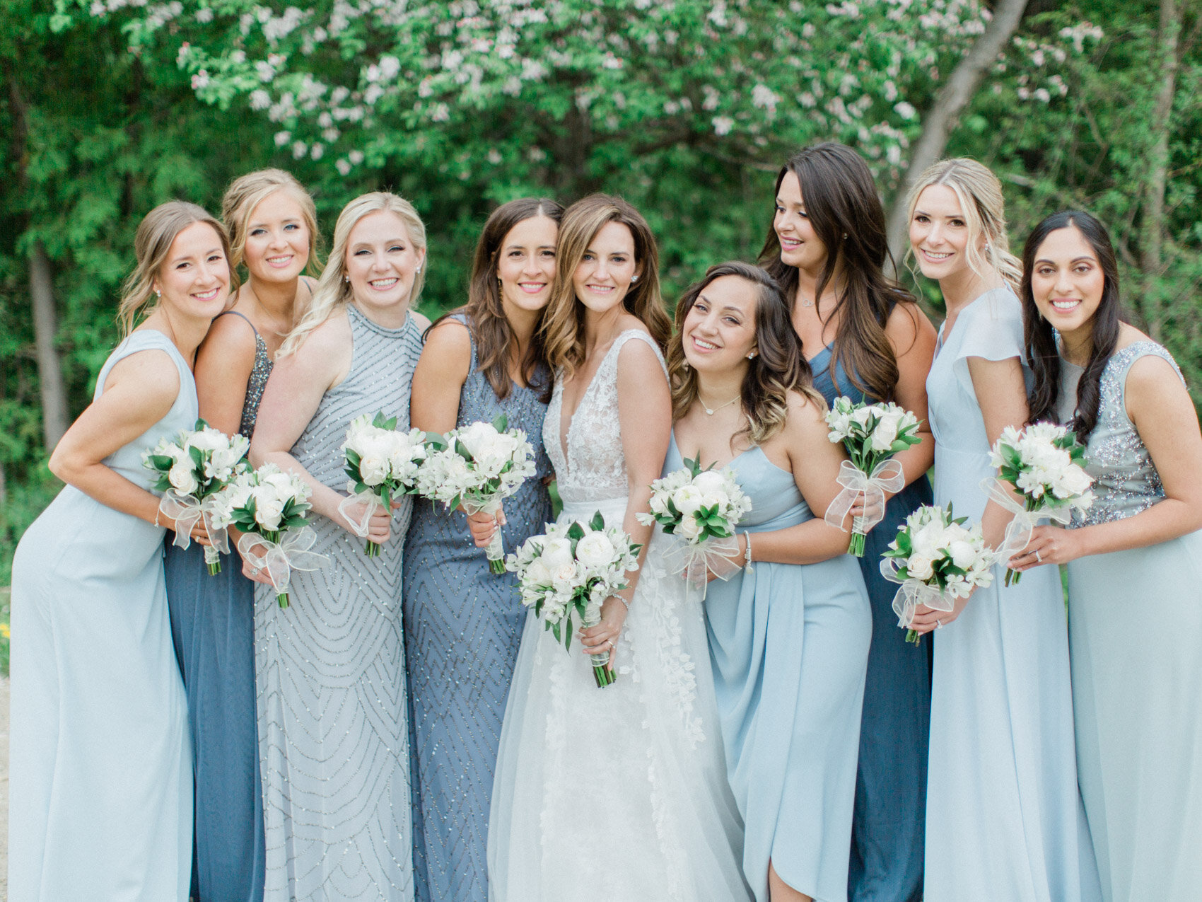 bridesmaids in soft blue posing naturally for wedding photos at alpine ski hill in collingwood