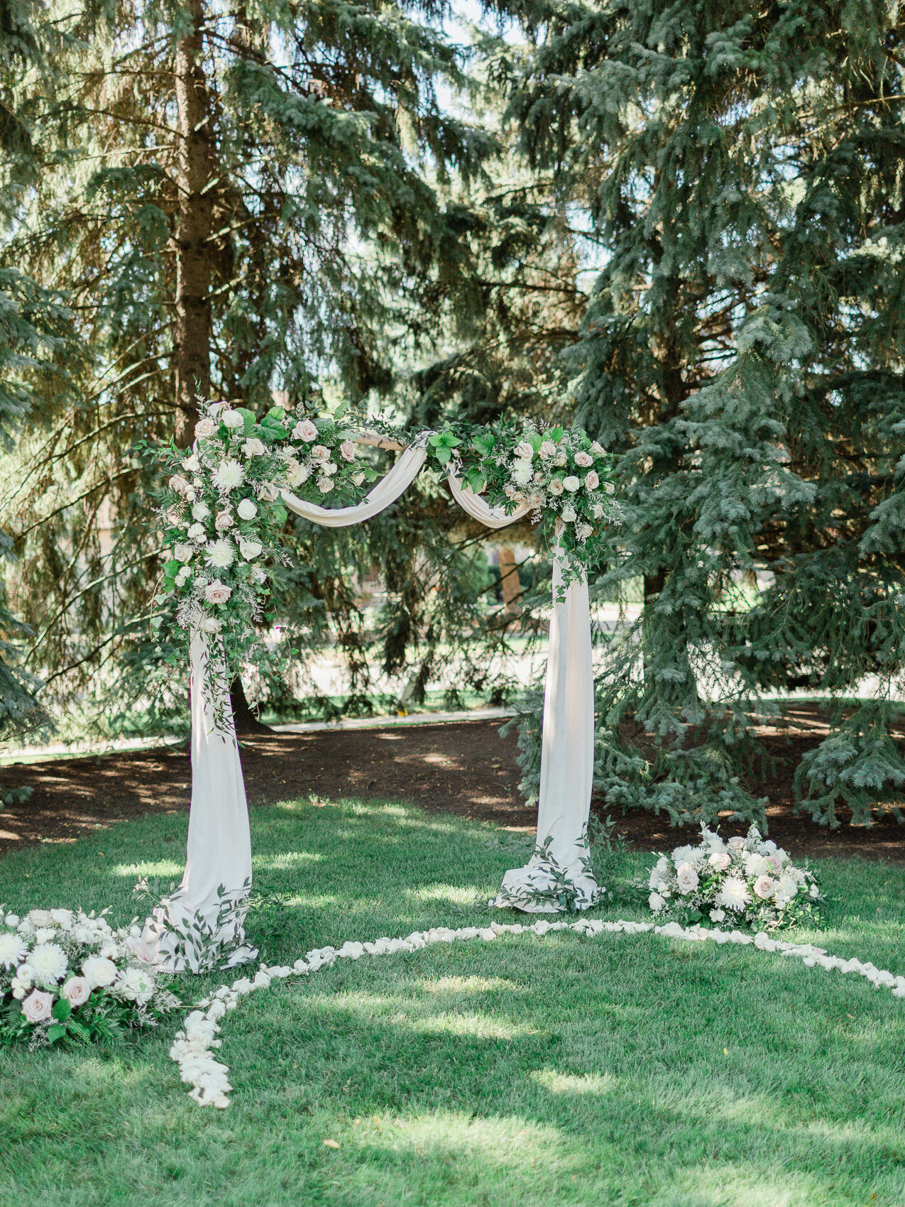 a classic floral wedding arch at a backyard wedding