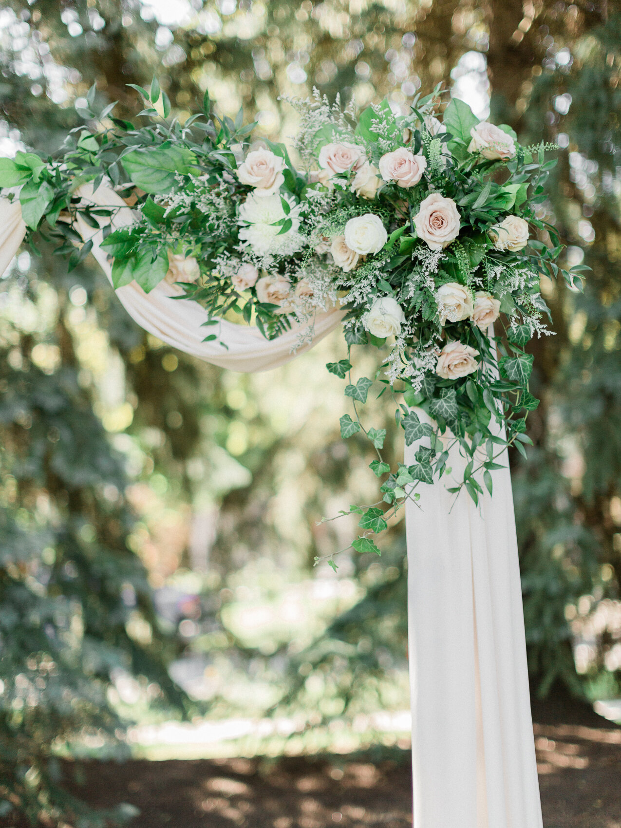 a classic floral wedding arch at a backyard wedding