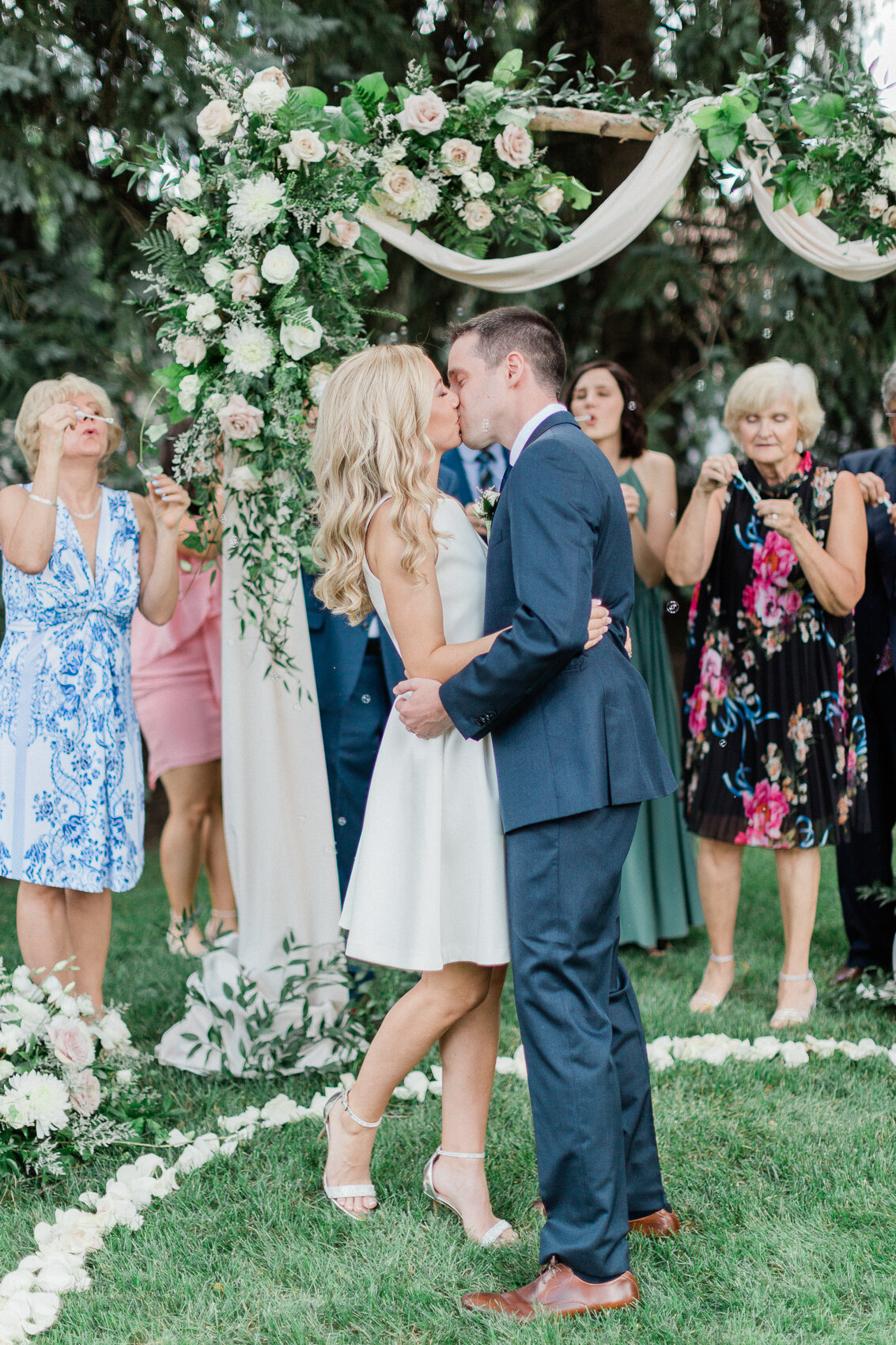 a couple pose naturally at their intimate backyard wedding