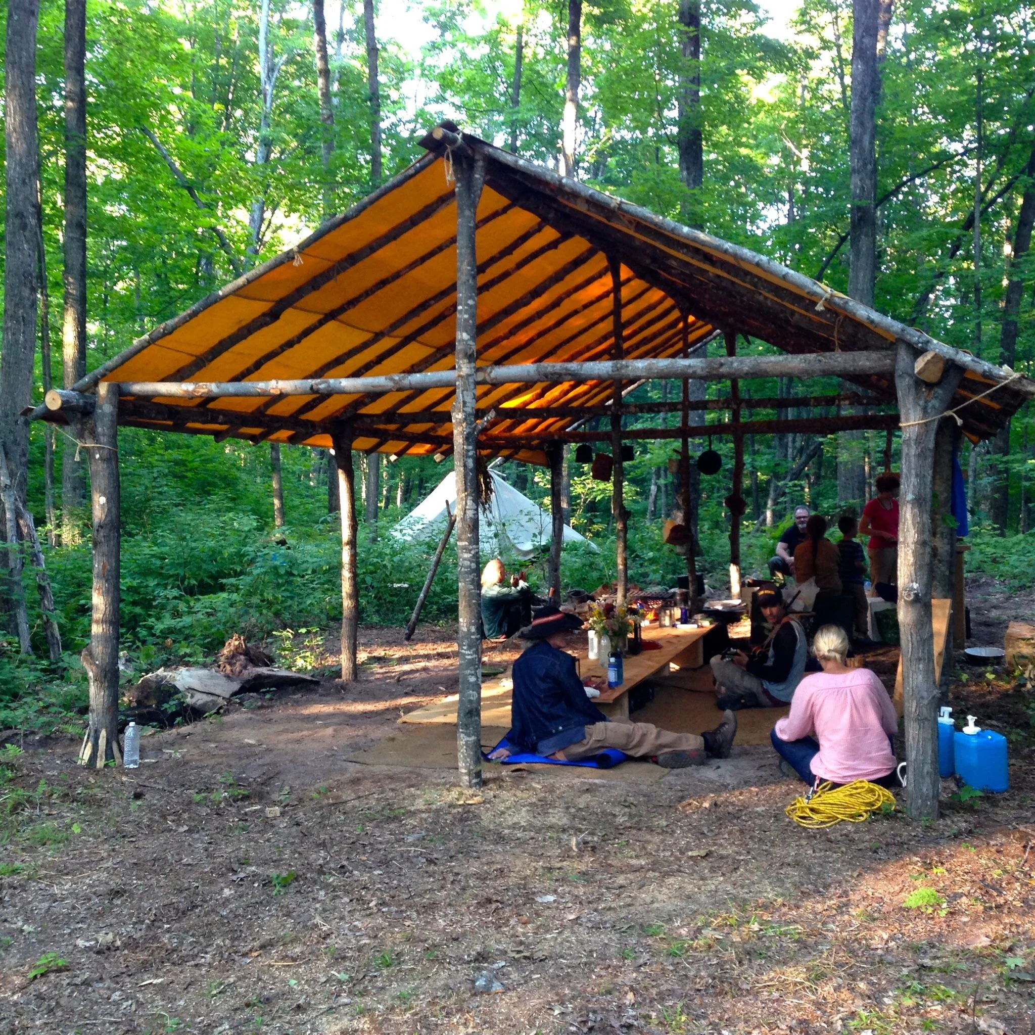 The community space had a table with ground seating. Toward the back is the cooking stove. We spent many hours here conversing, listening to live music, and sharing delicious, healthy meals. Jan and Rochelle's teepee is in the back.