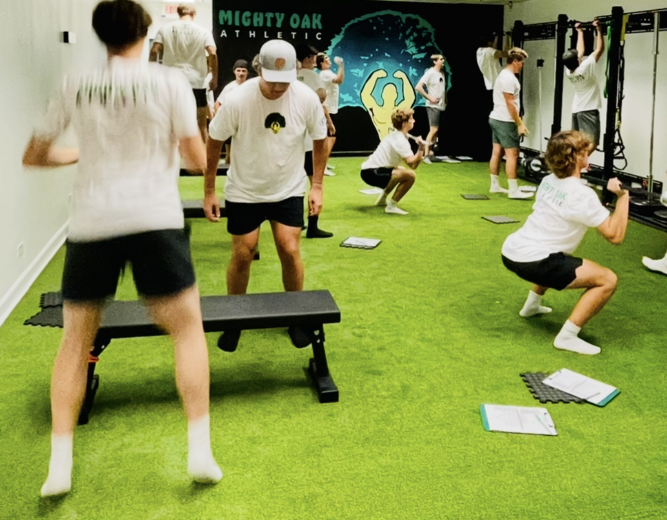 Youth athletes doing squats and step-ups during a group strength session at Mighty Oak Athletic in Westmont